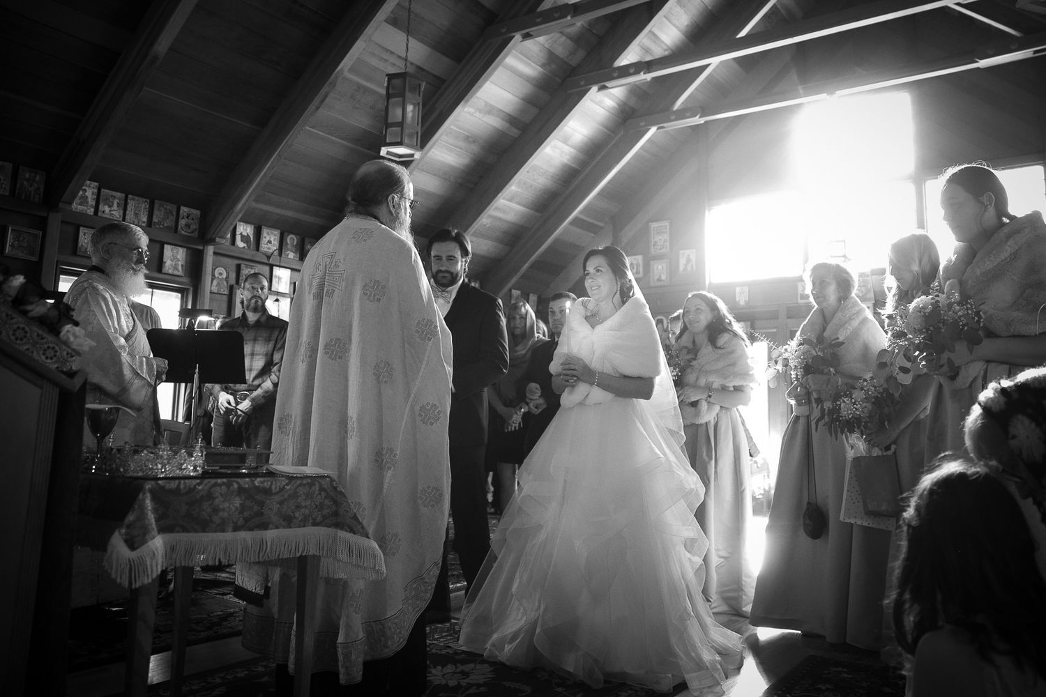 Black and white photo of a bride and groom exchanging vows at a church wedding ceremony.