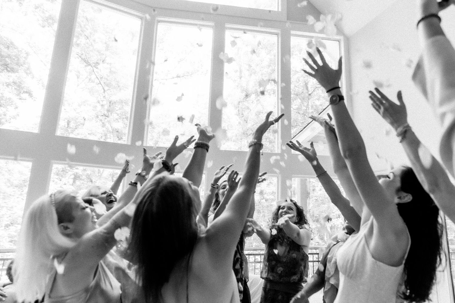 Crowd of people with raised hands celebrating at an indoor event.