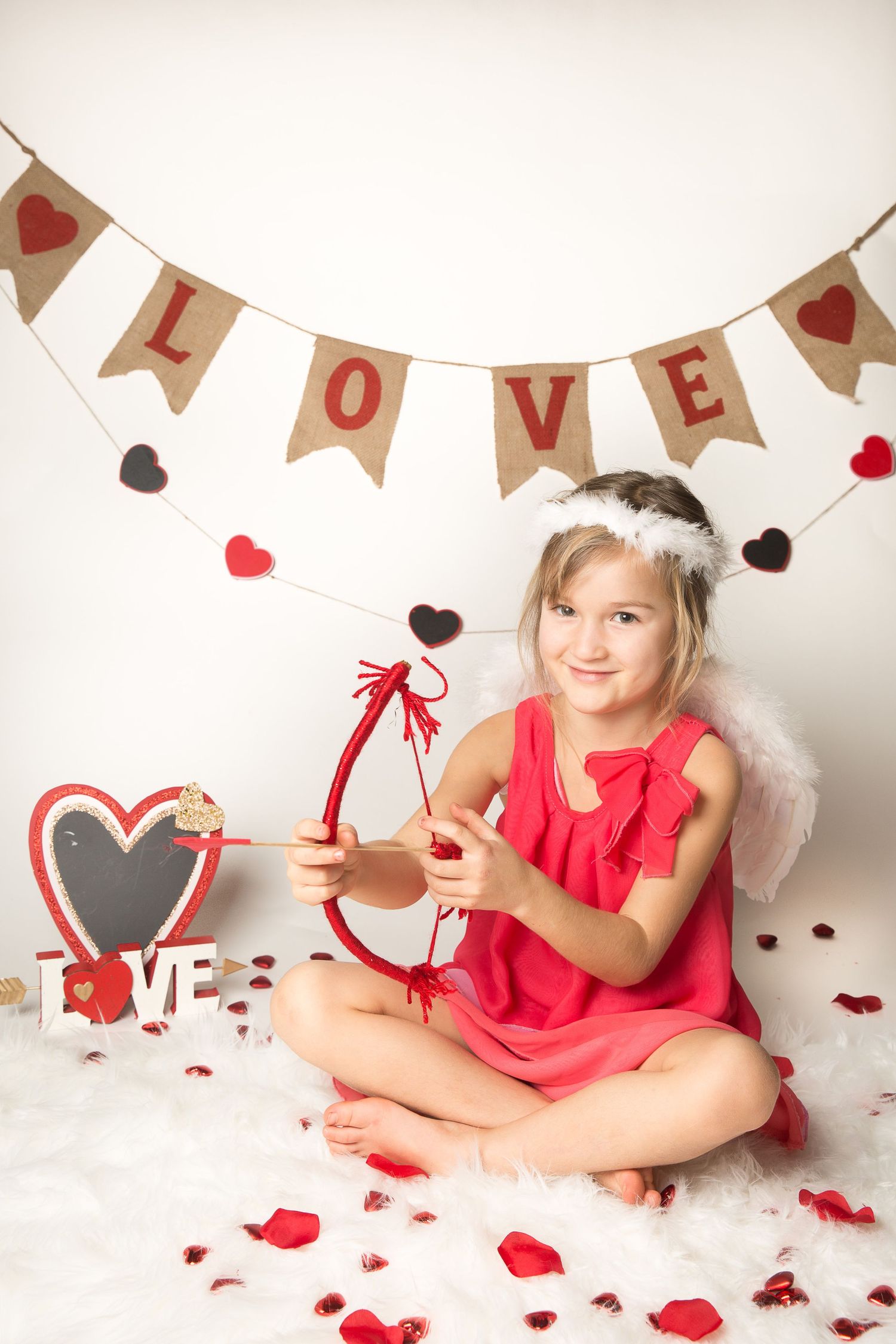Valentine's day themed portrait with red hearts, love banner and festive decorations.