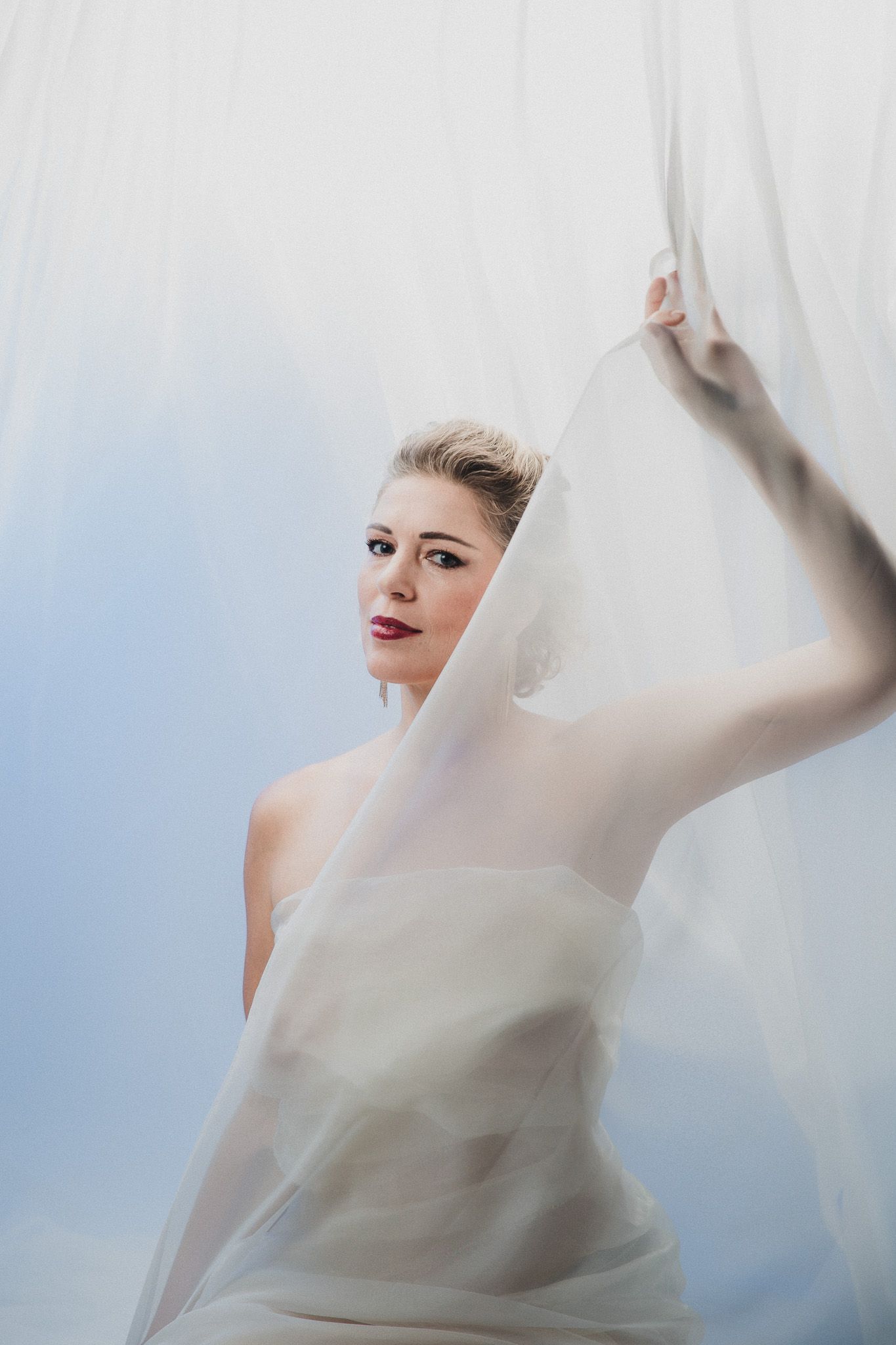 Artistic portrait series with flowing white fabric and ethereal lighting effects.