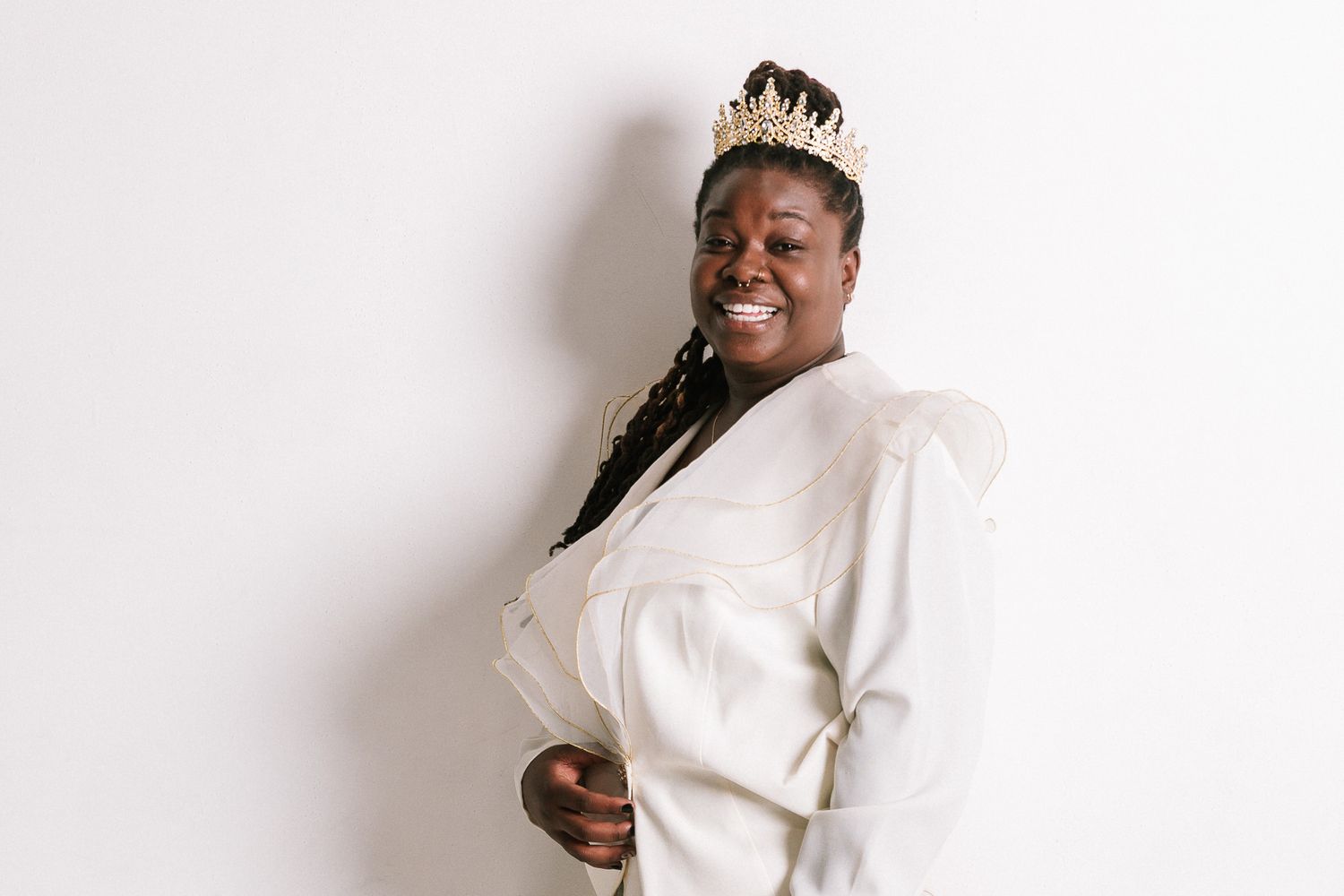 Joyful portrait against white background wearing elegant white jacket.