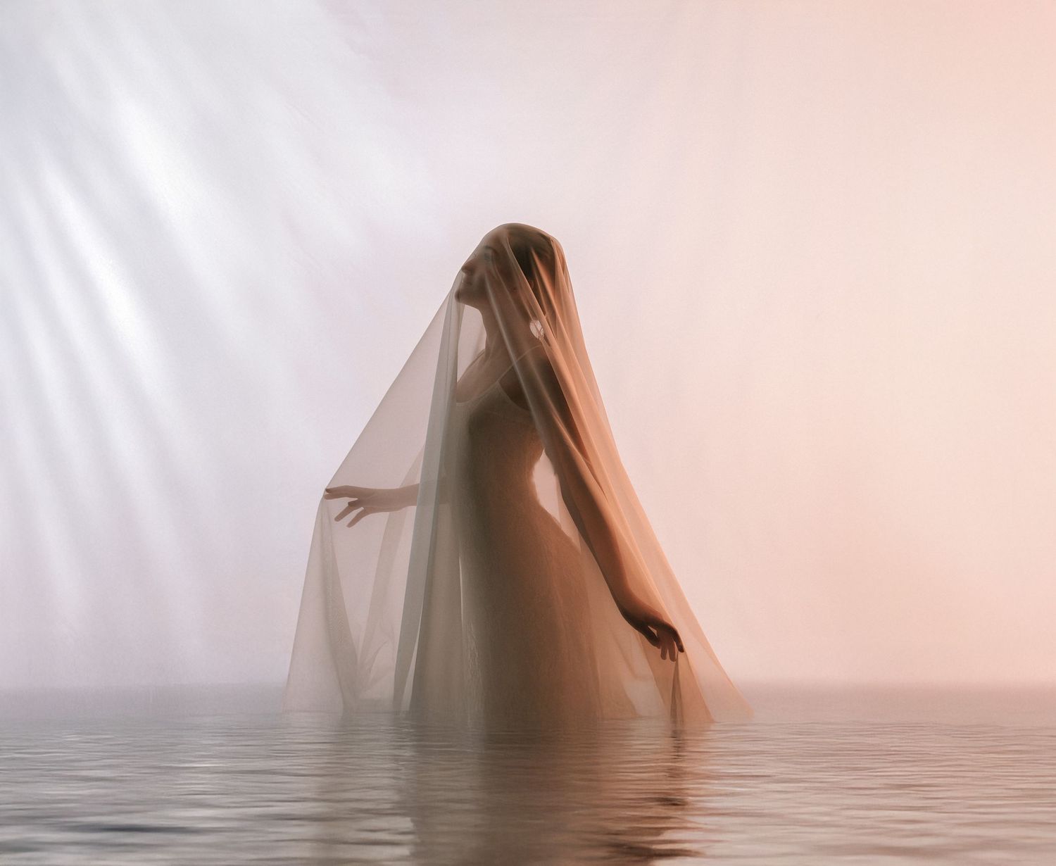 Figure emerging from water draped in translucent fabric creating mystical atmosphere in pink-tinted light.