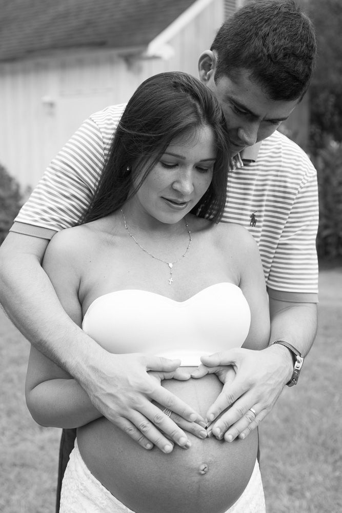 Intimate outdoor maternity portraits with couple in white dress and striped shirt.