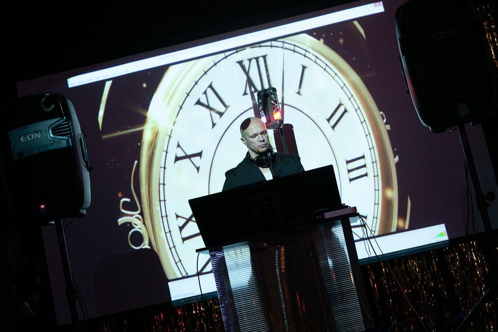Large illuminated clock display backdrop at an event venue.