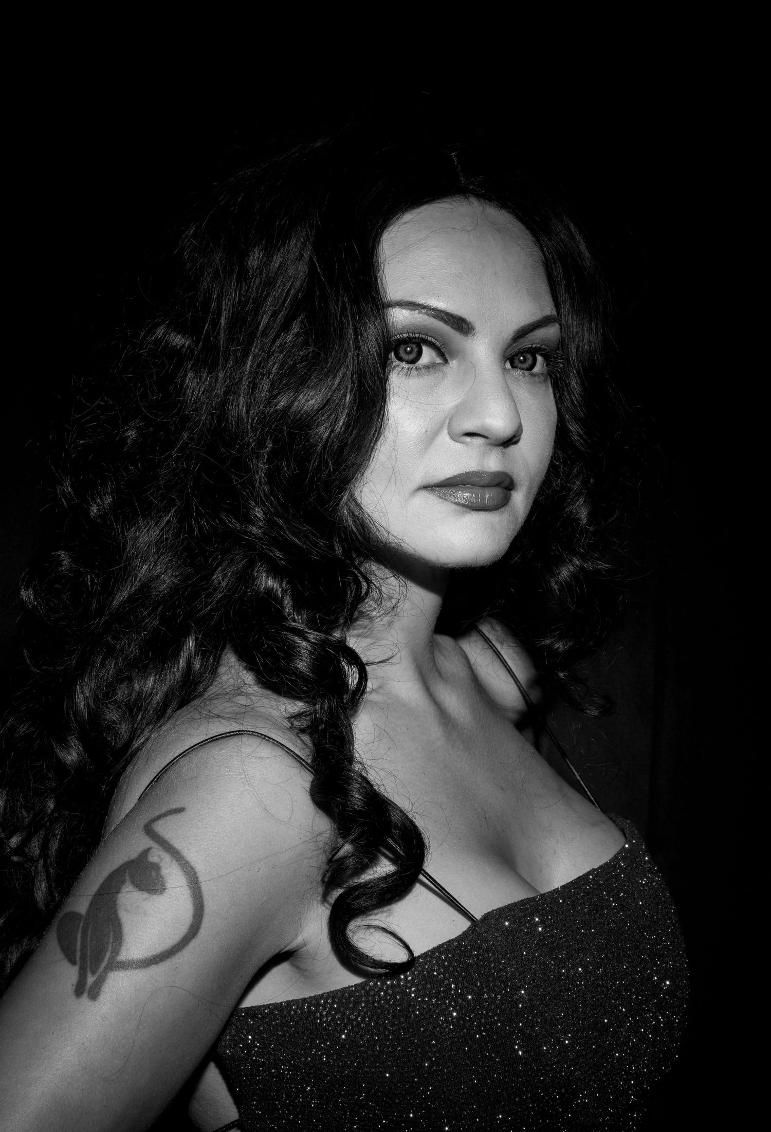 Dramatic black and white portrait series featuring dark curly hair and sparkly dress details.