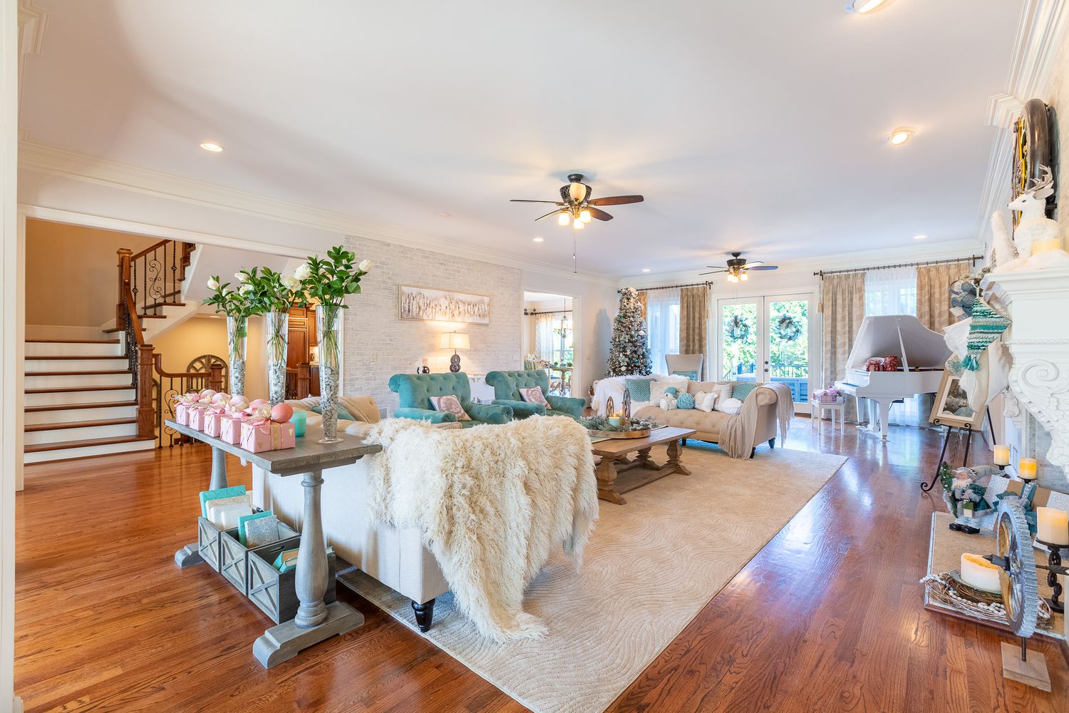 Panoramic view of a bright modern open concept living space with white walls and hardwood floors.