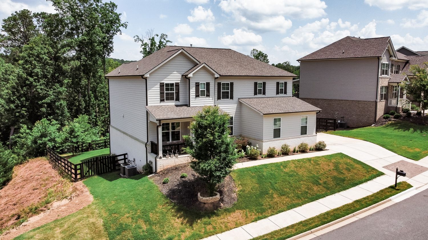 Bird's eye view of suburban houses with well-maintained lawns and driveways.