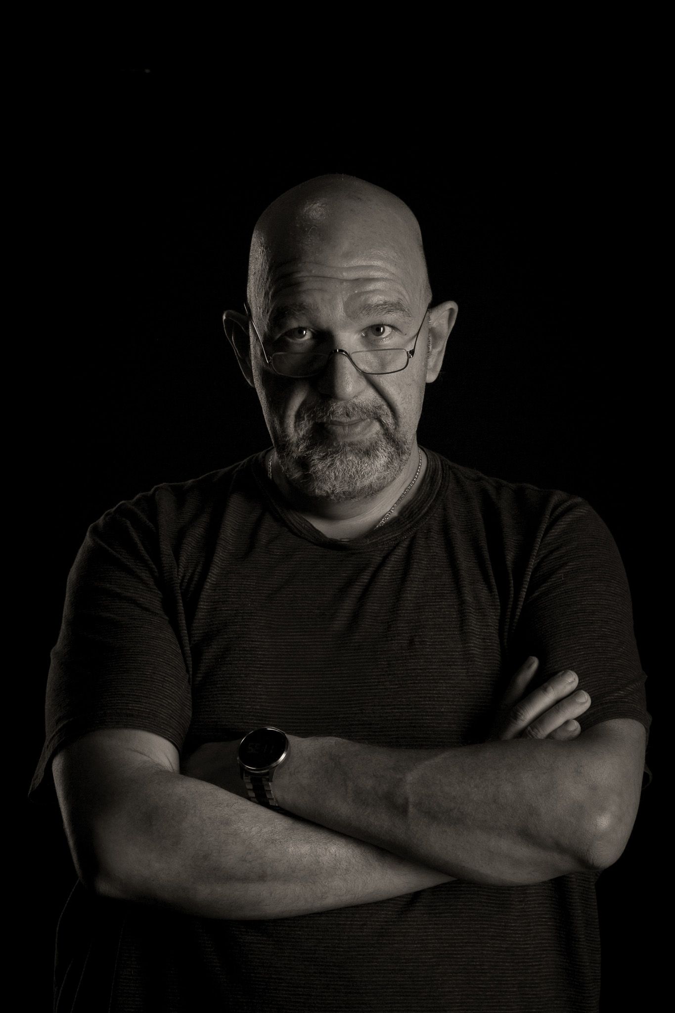 A series of dramatic black and white portraits showing someone in a dark t-shirt against a black background.