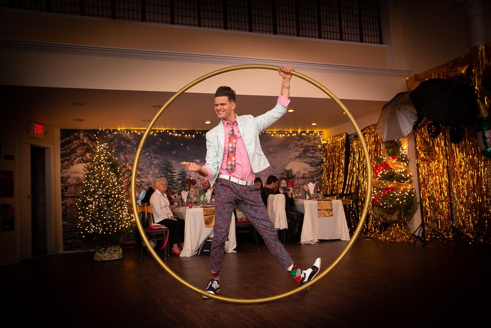 Performer spinning inside a large golden hoop on stage at an event venue.