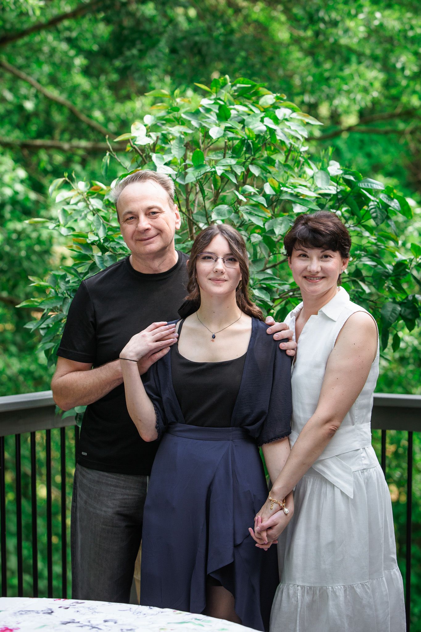 Group photo sequence on outdoor deck with greenery backdrop.