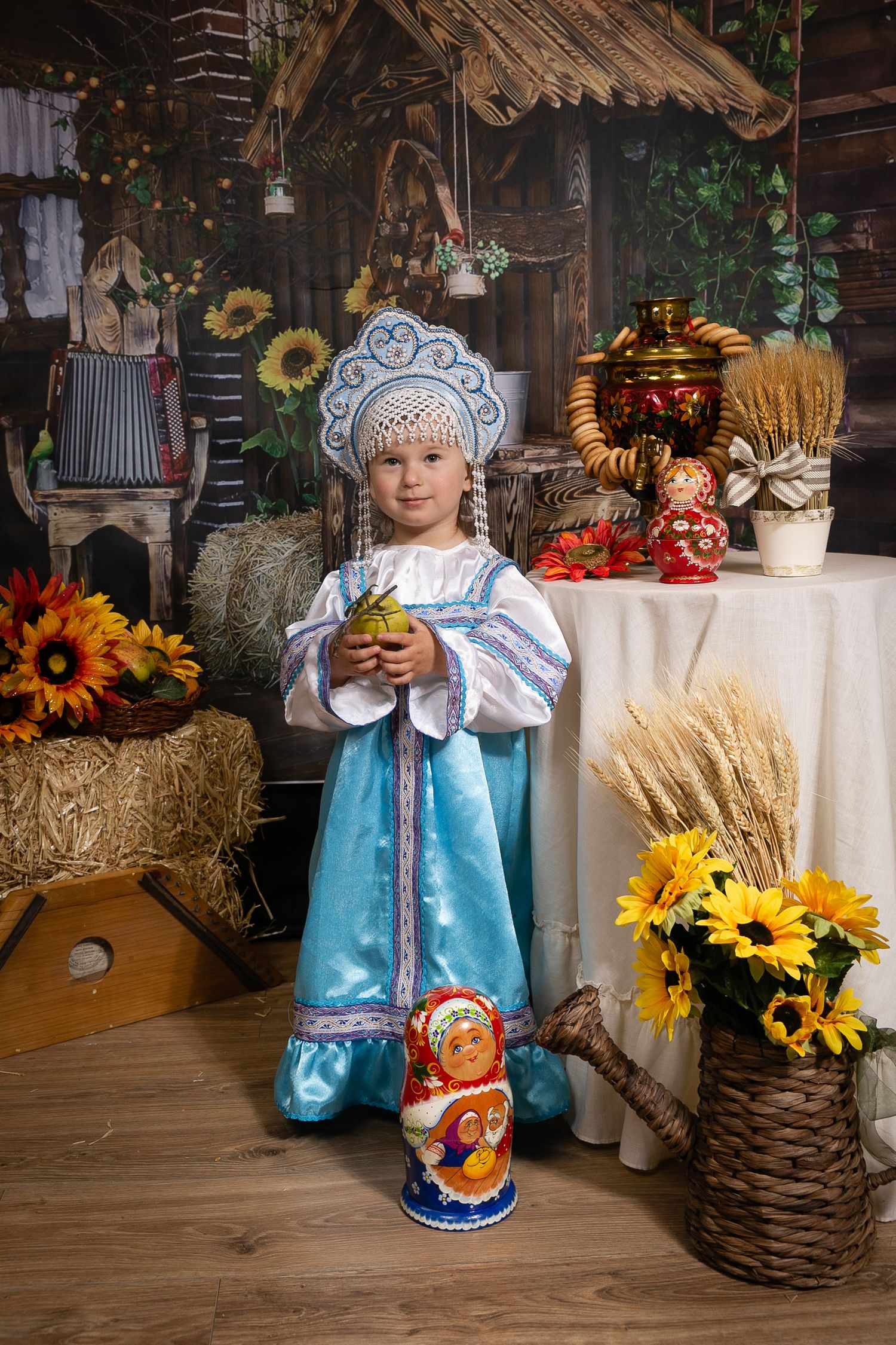Traditional Russian folk costume photoshoot with sunflowers and rustic decor elements.