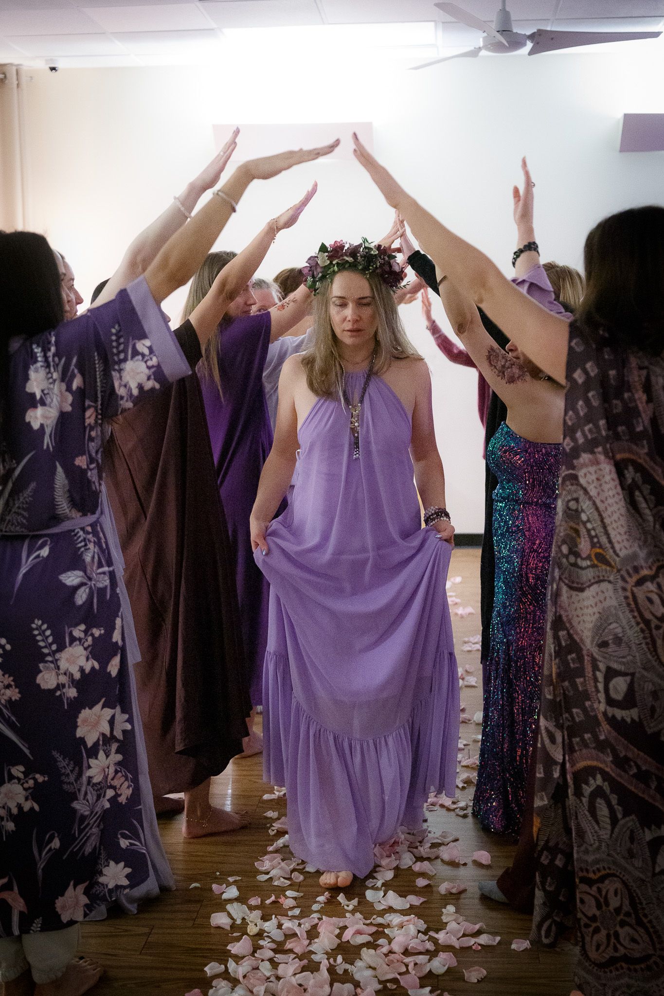 Group of people in flowing dresses with raised arms performing a choreographed dance.