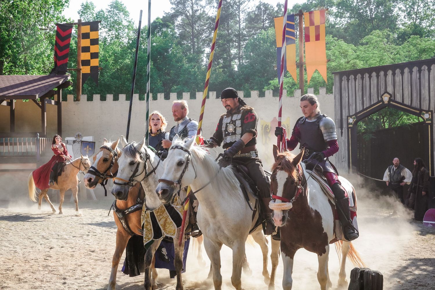 Medieval combat performers with horses and weapons demonstrating historical battle techniques.