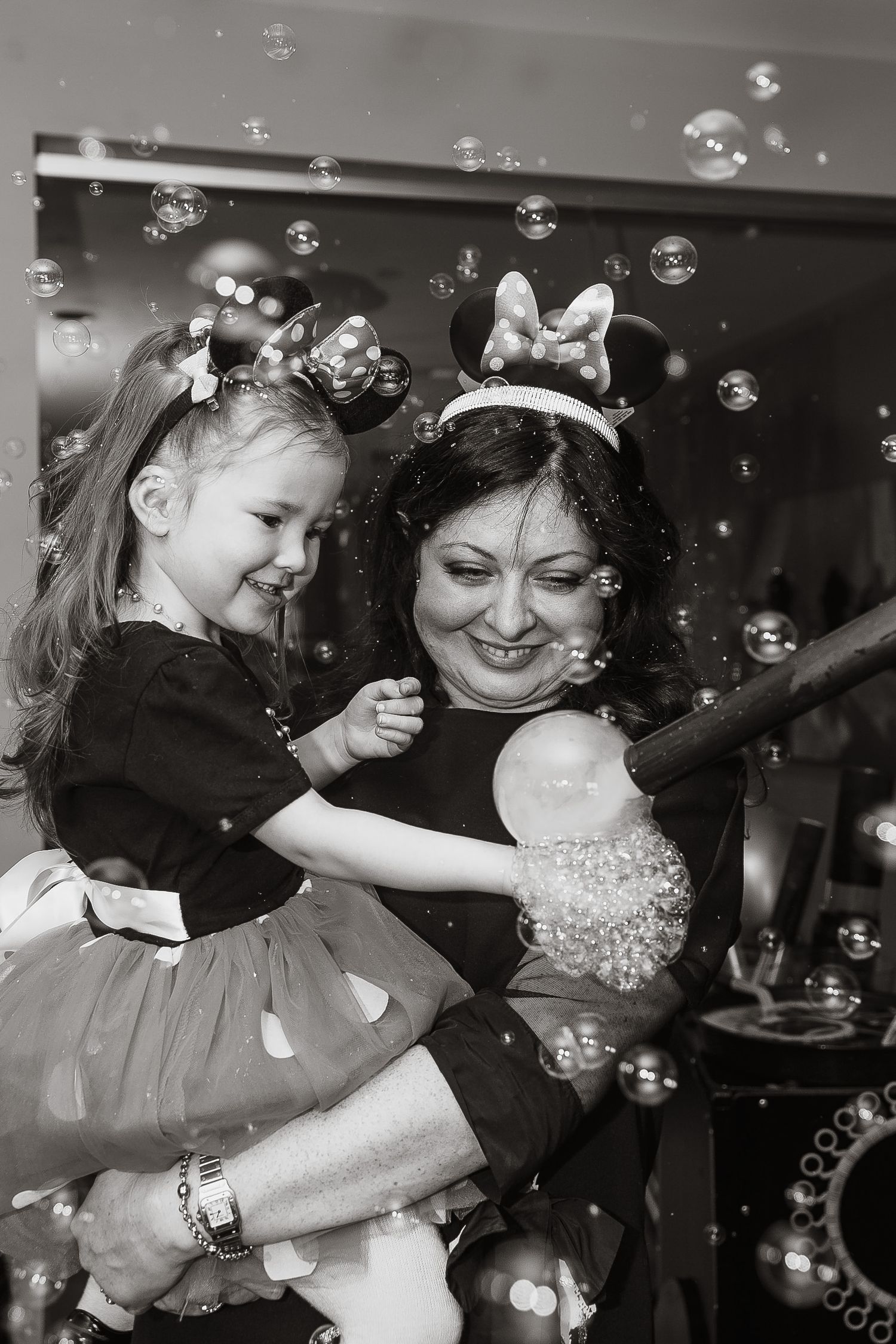 Black and white photo of joyful celebration with bubbles floating through the air.