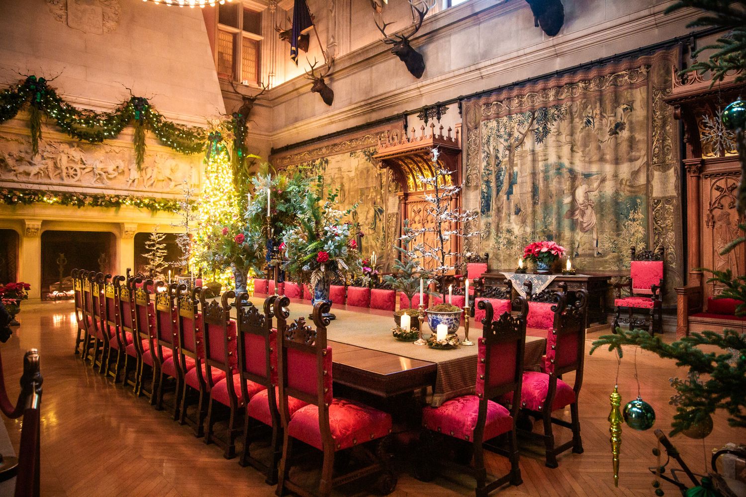 Elegant restaurant dining room with red upholstered seating and romantic mood lighting.