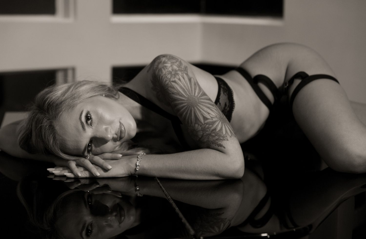 Intimate black and white portrait showcasing tattoo art and lingerie.