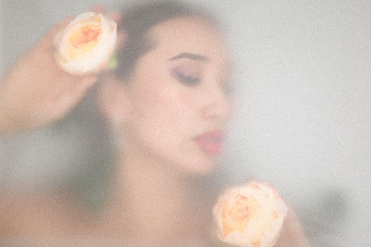 Soft focus beauty portrait with warm peachy tones and gentle lighting.
