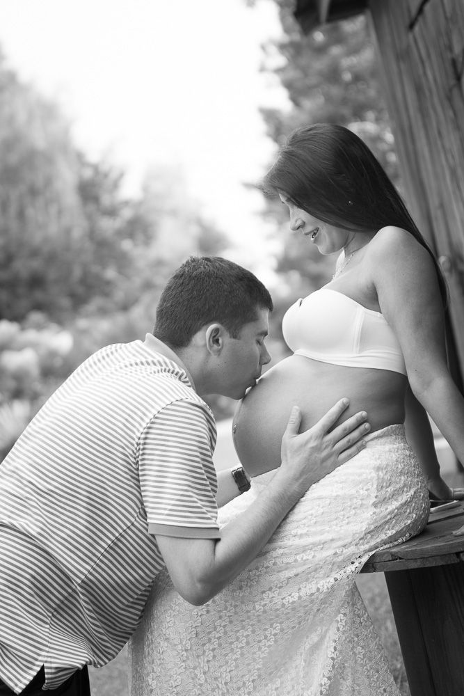 Black and white maternity series capturing tender moments between expectant couple.