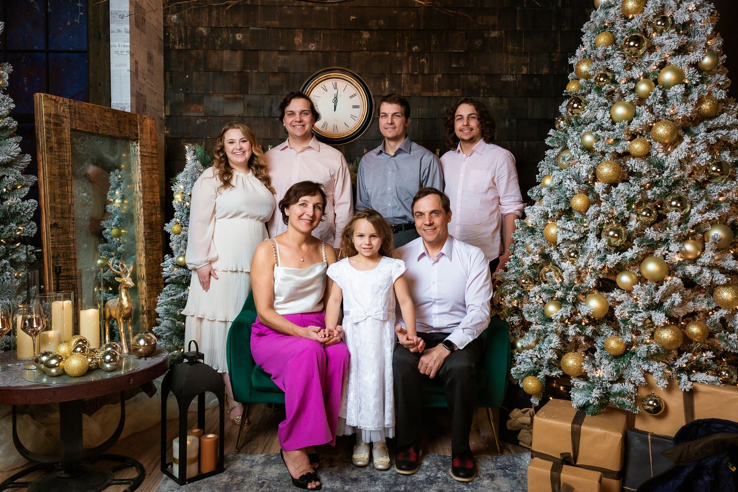 Candid family moment captured by decorated Christmas tree with vintage props and warm lighting.