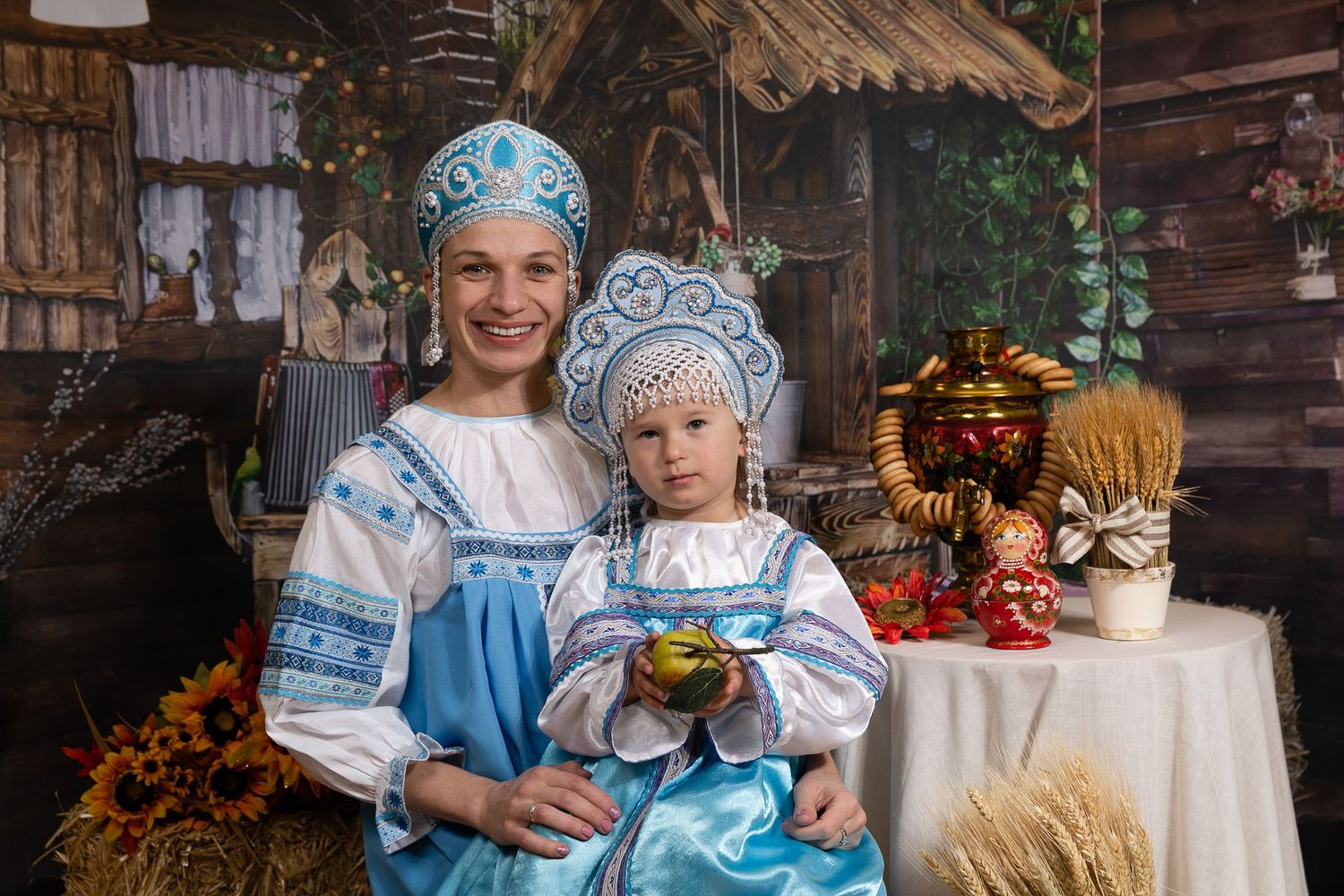 Traditional Russian folk costumes in blue and white with decorative elements in rustic setting.