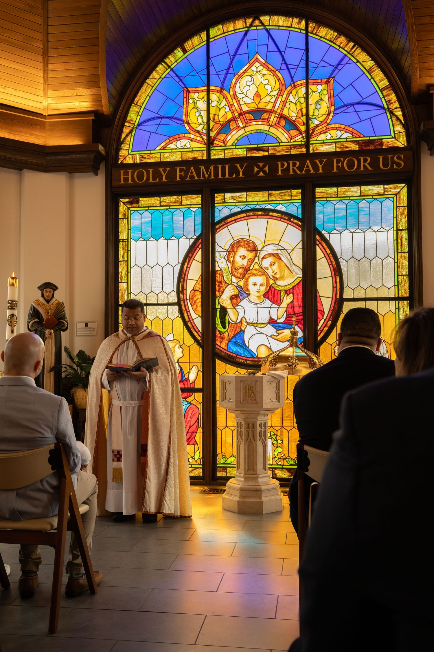 Beautiful stained glass windows illuminated inside church with religious figures.