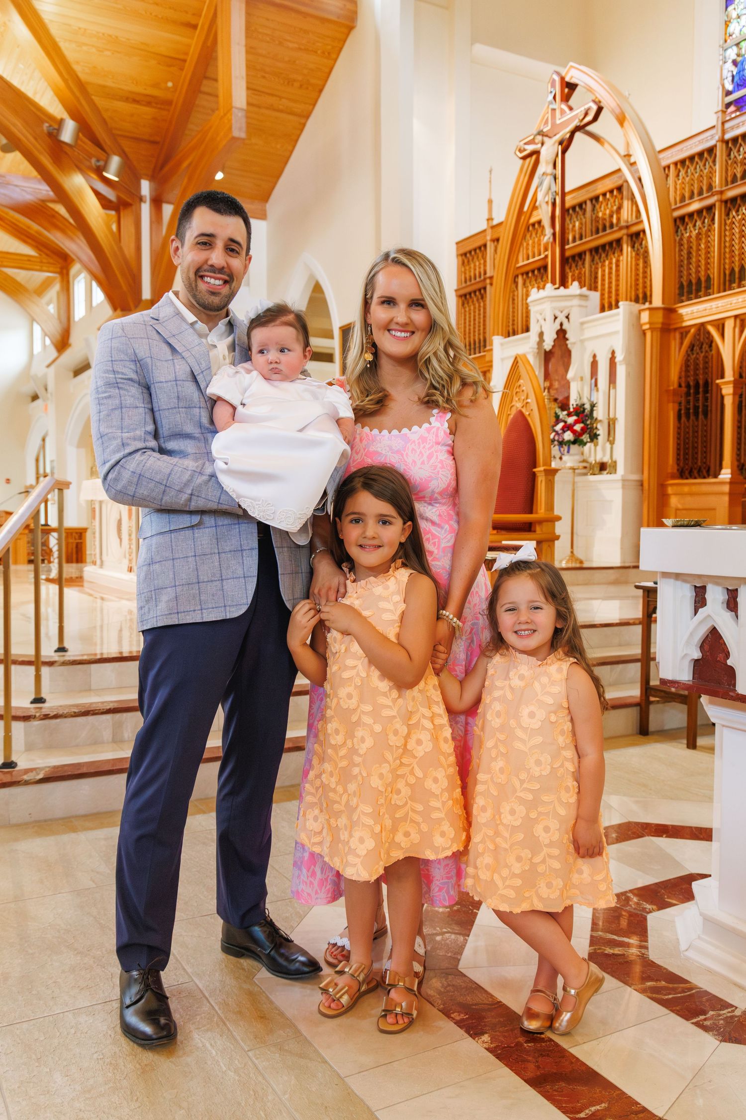Family gathering in church wearing coordinated peach and gray outfits.
