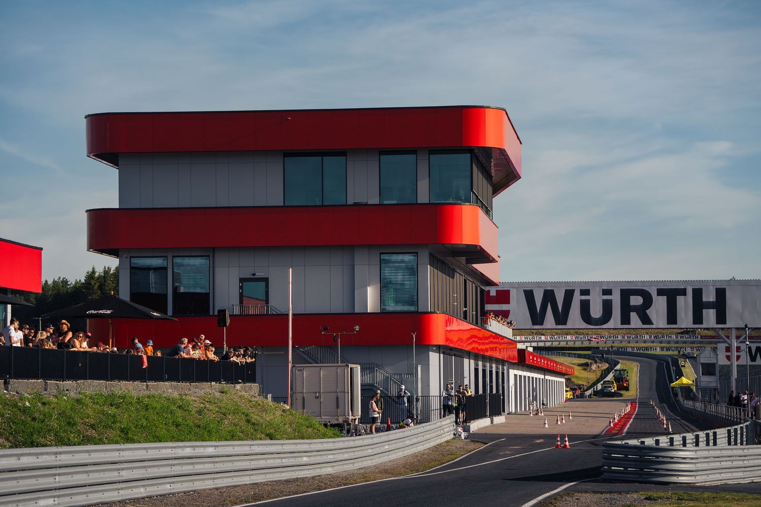 Modern industrial building with red accents and Wurth signage against blue sky with multiple loading docks.