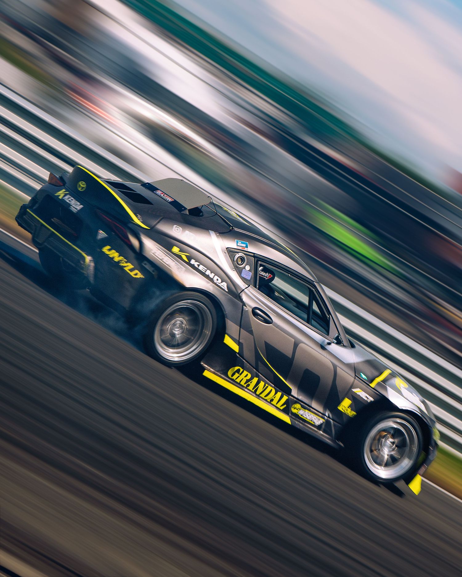 Motion-blurred sports cars racing on a track with dramatic panning shots showing speed and movement.