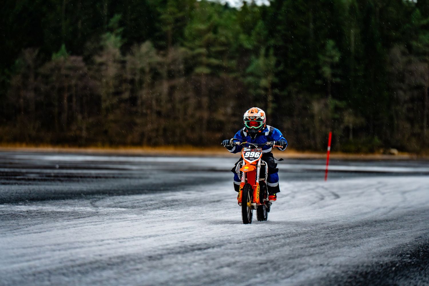 A snowmobile rider navigates through a snowy winter landscape on a forest trail during a winter sports adventure.