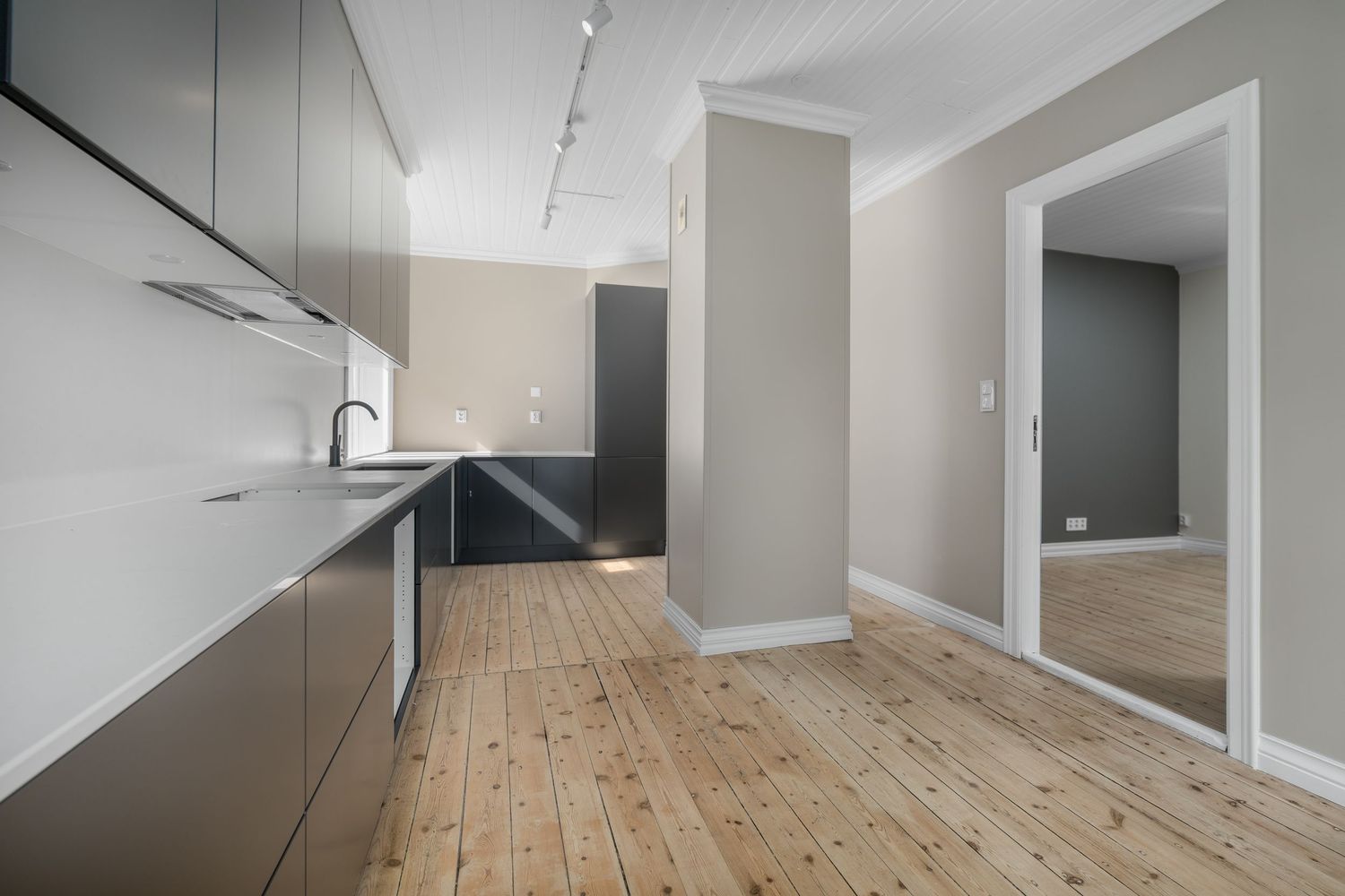 Modern kitchen with sleek cabinets and natural wood flooring.