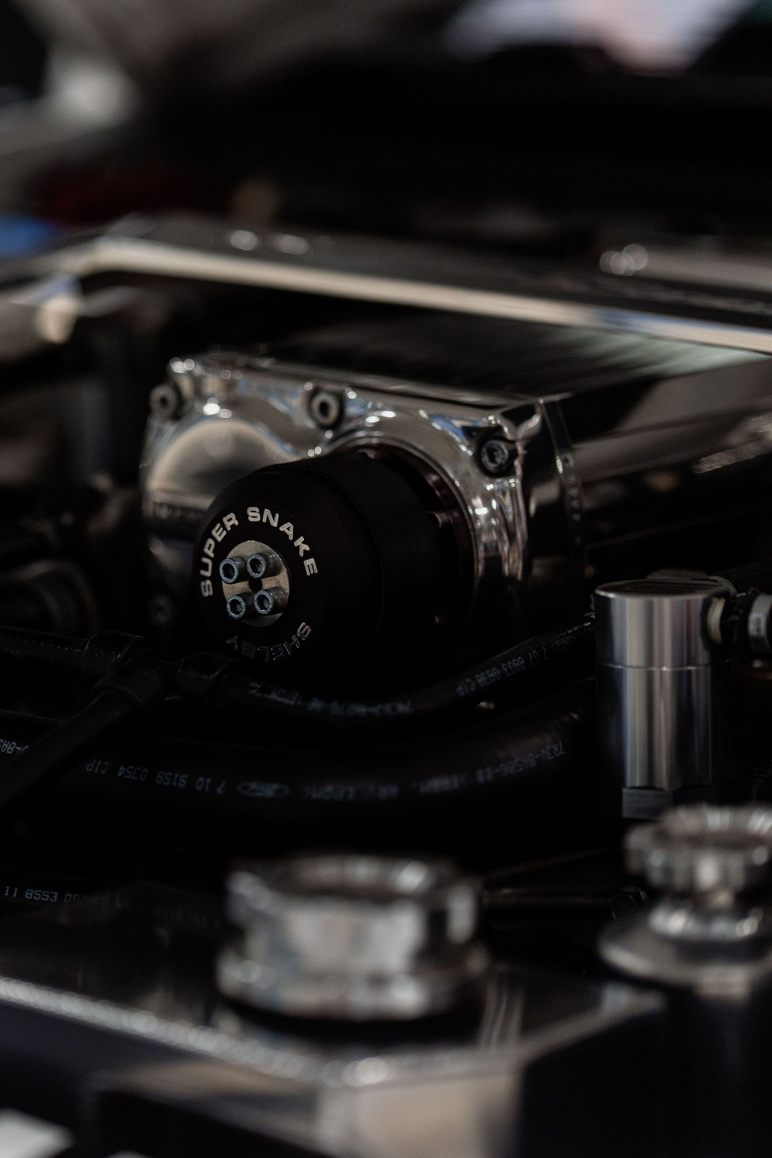 Close-up detail of a classic car engine component with mechanical parts in dark lighting.