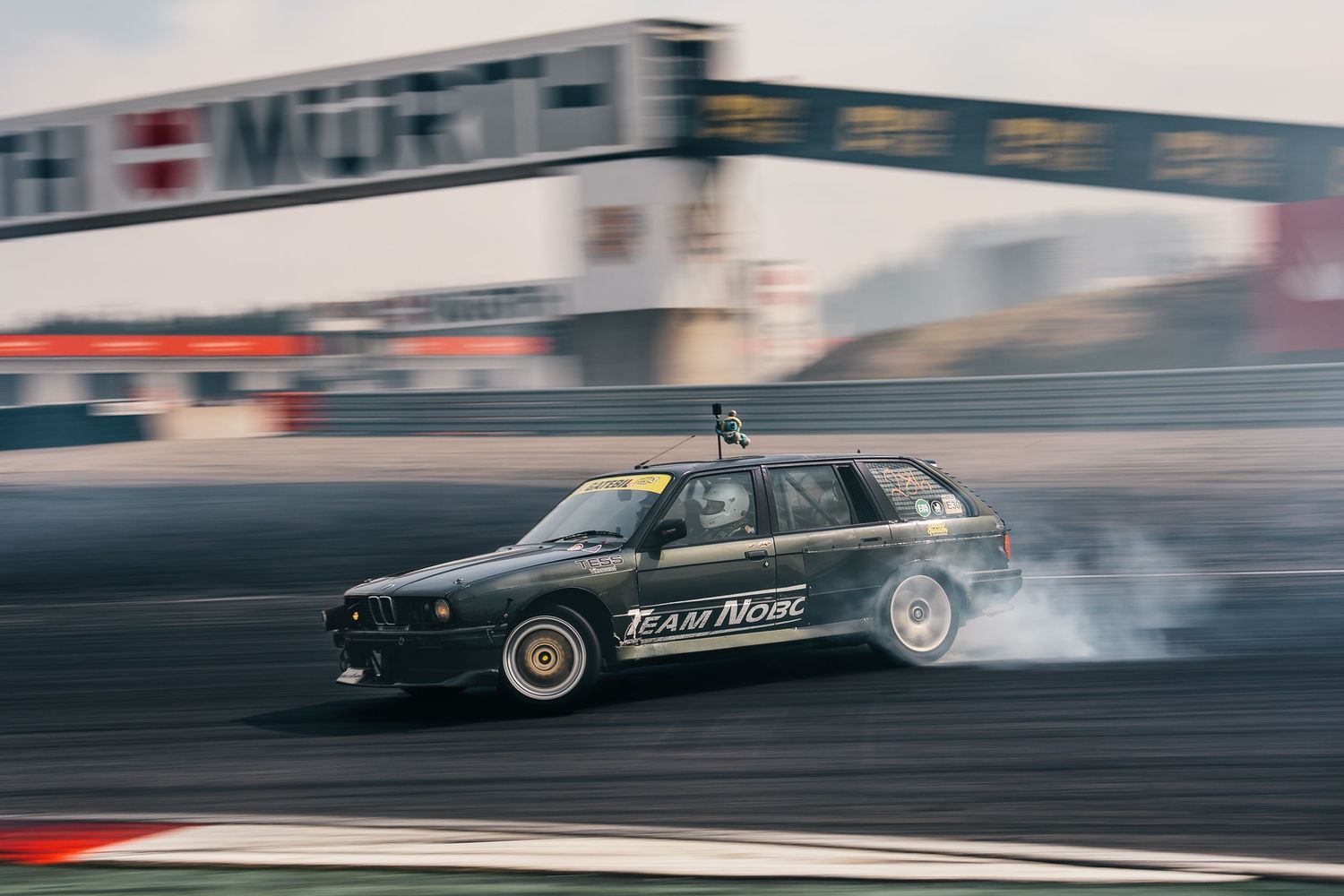 Vintage drag racing car speeding down a racetrack with motion blur effect creating a dramatic sense of speed and power.