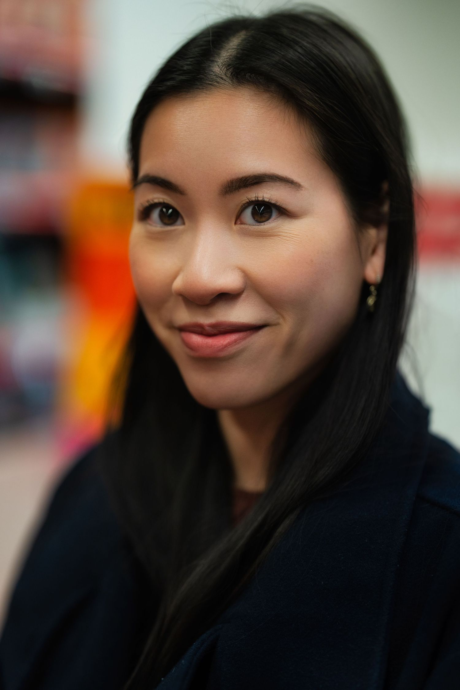 Professional headshot against blurred background showing gentle smile.