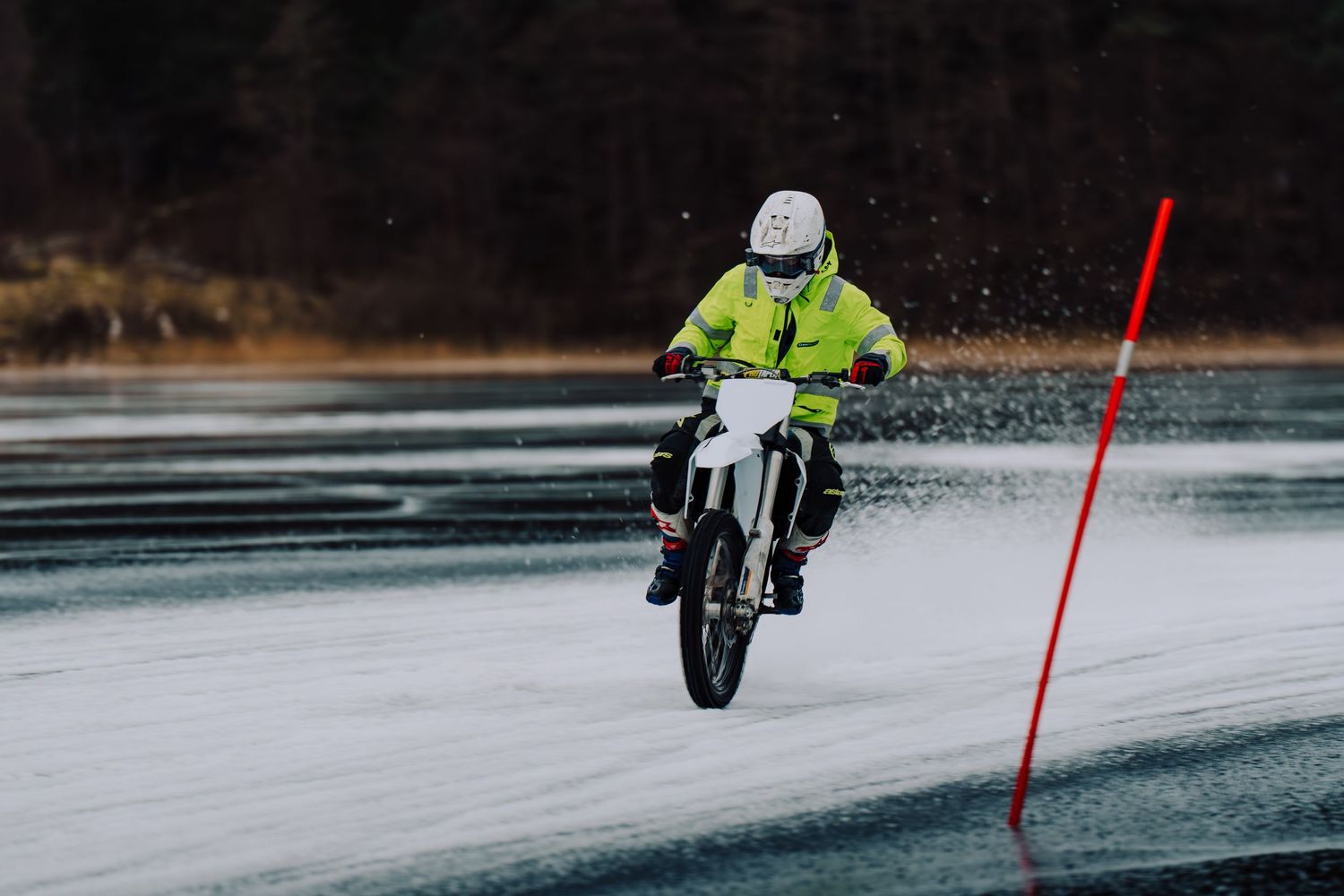 A motorcycle rider leans through a series of turns on a wet racetrack during a rainy day session.