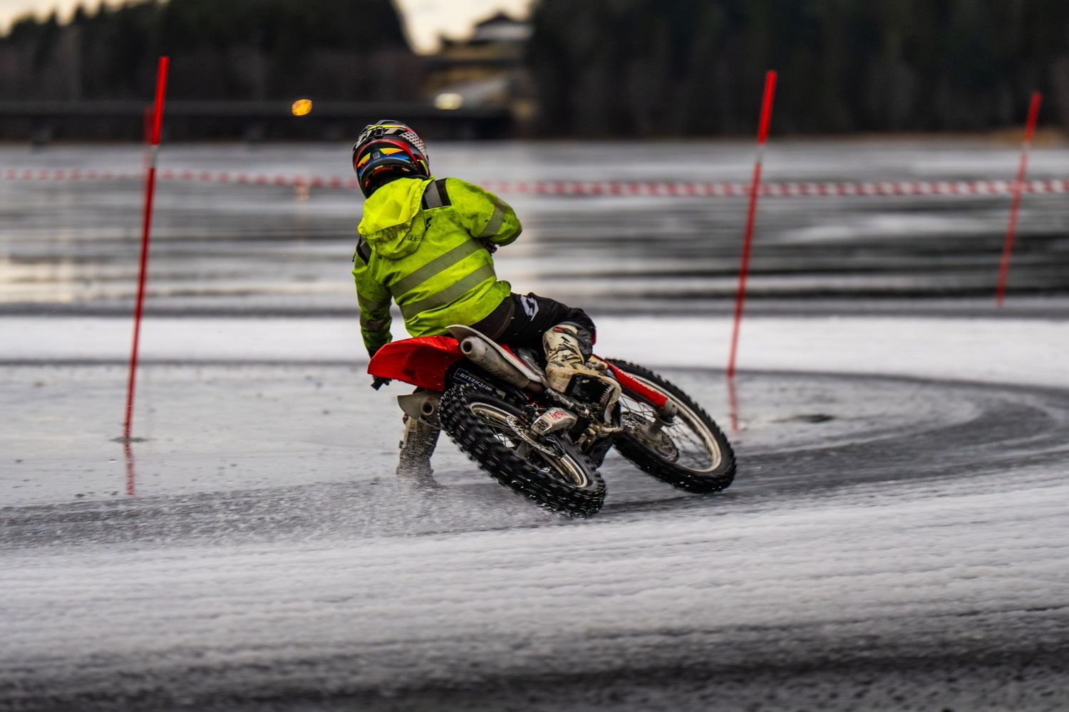 A sequence of action shots showing a cyclist performing a sliding maneuver on a snowy surface.