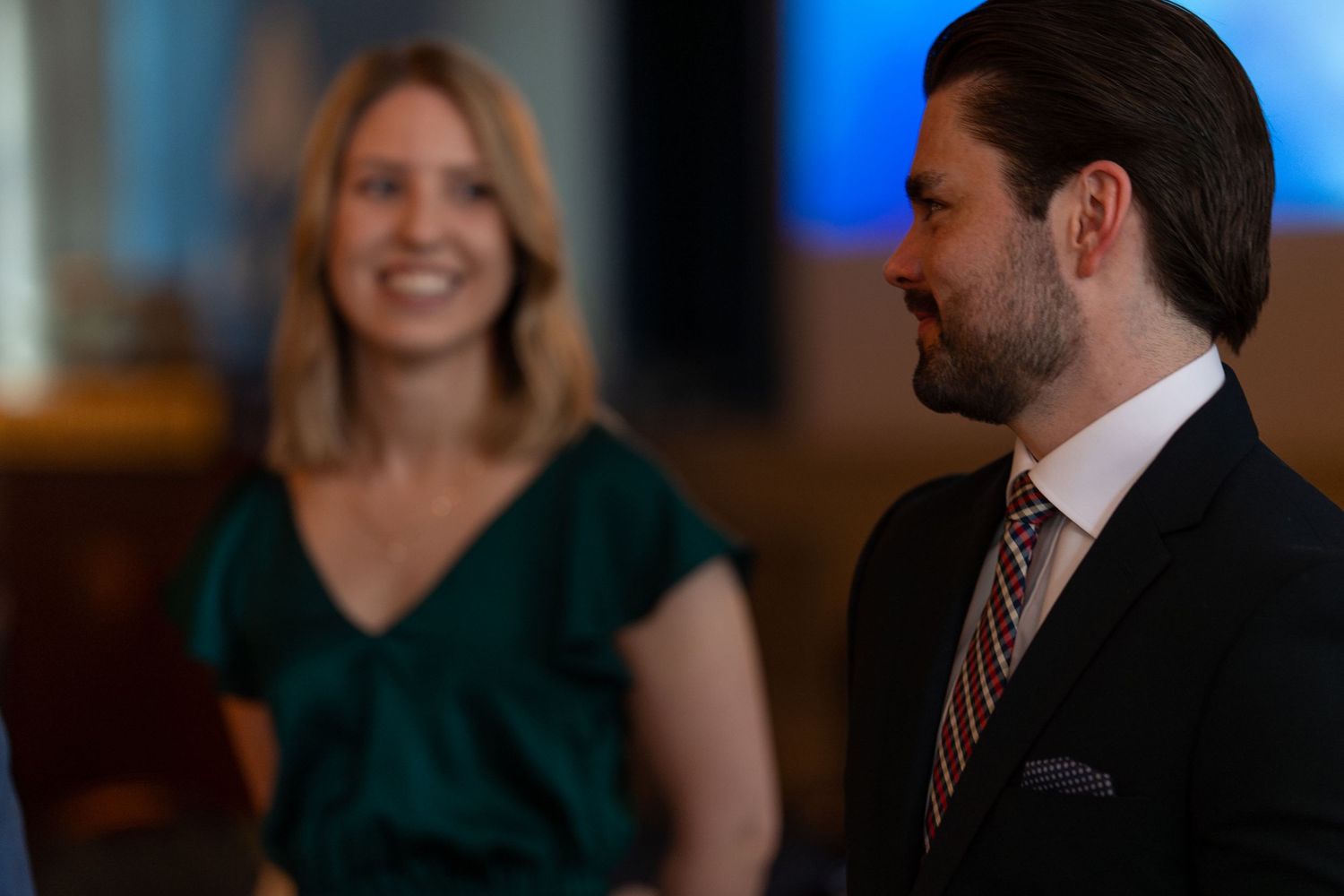 Guests mingling at a formal event with soft lighting and warm atmosphere.