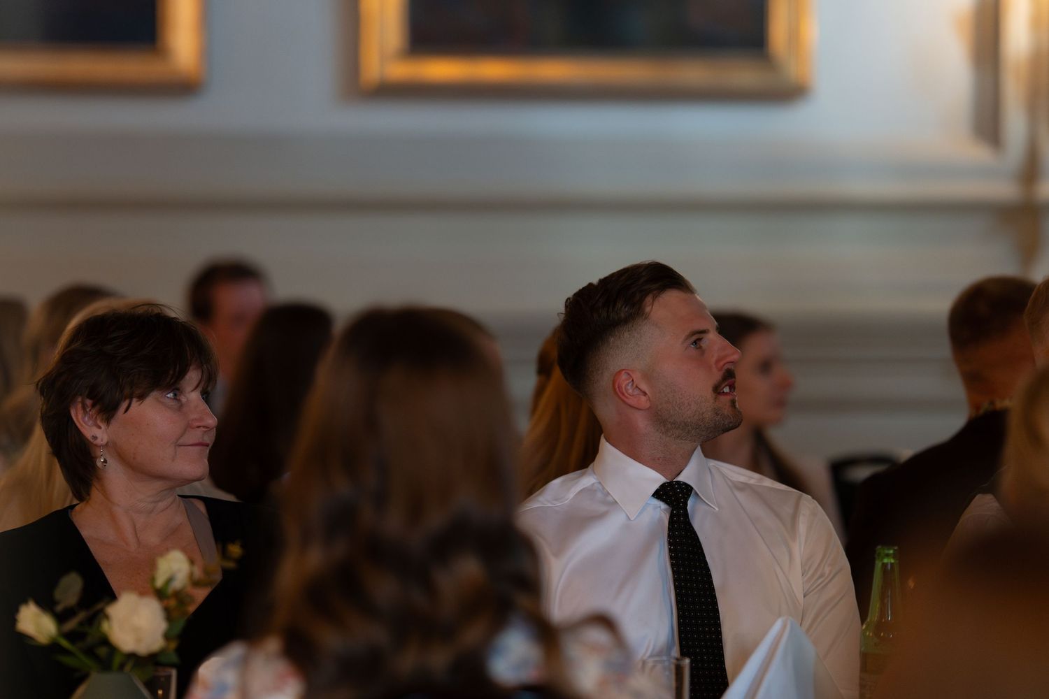 Event attendees listening intently during formal business presentation.