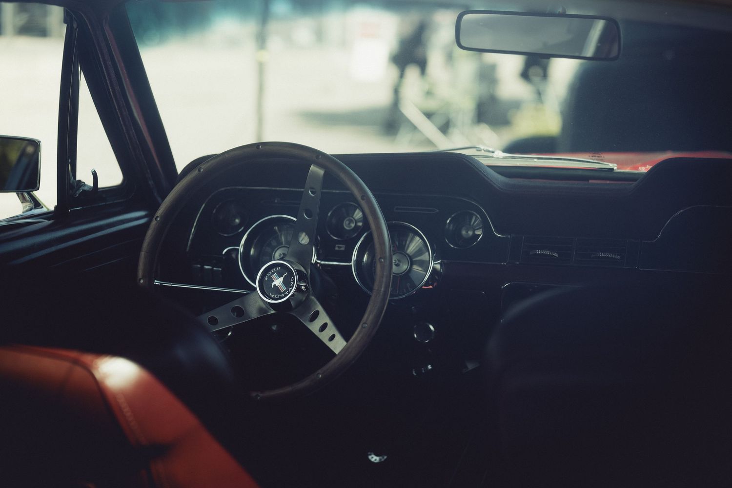 Vintage car interior dashboard with classic steering wheel and gauges.