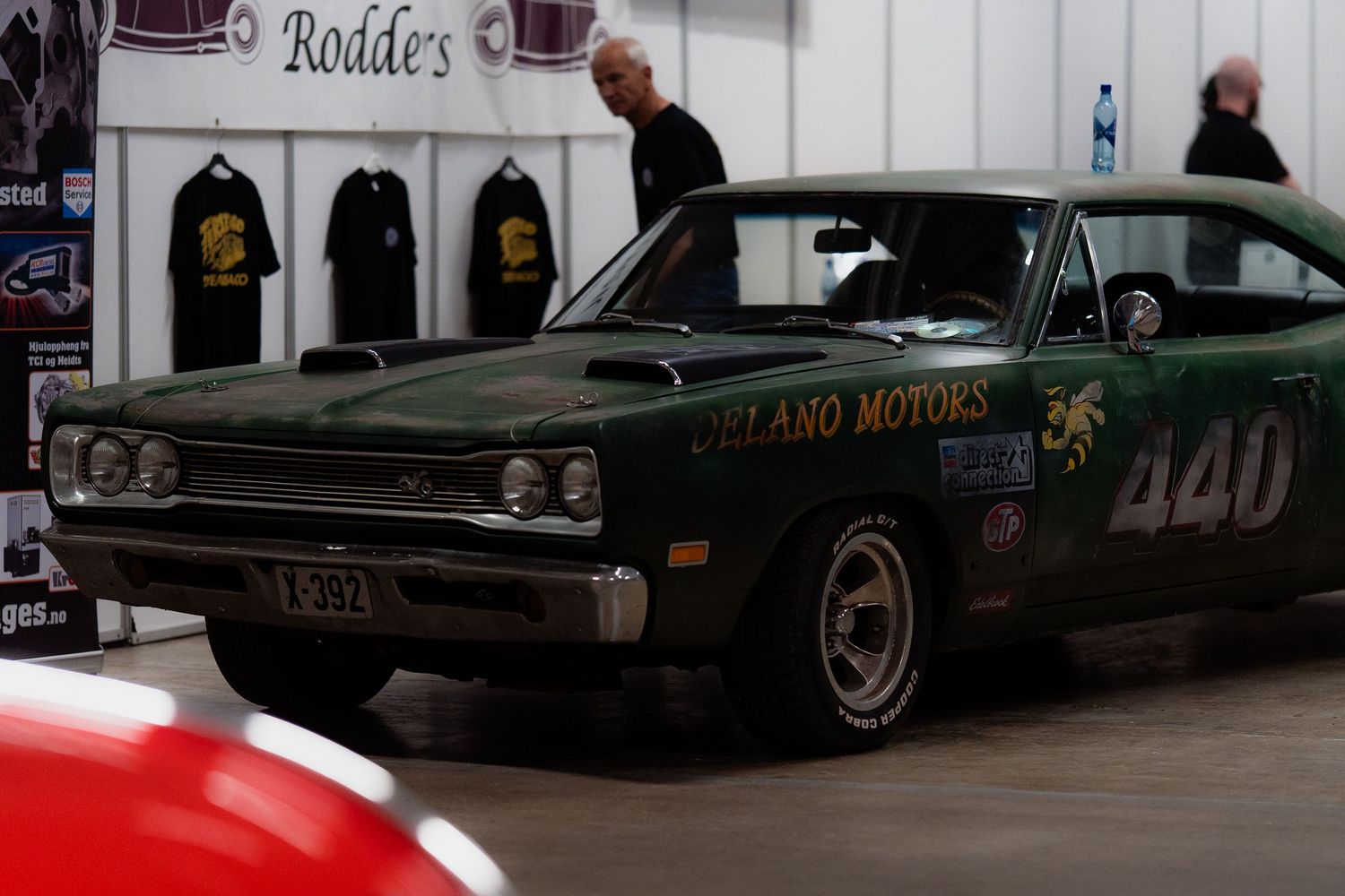 Row of vintage classic cars parked at a car show displaying dark paint finishes.