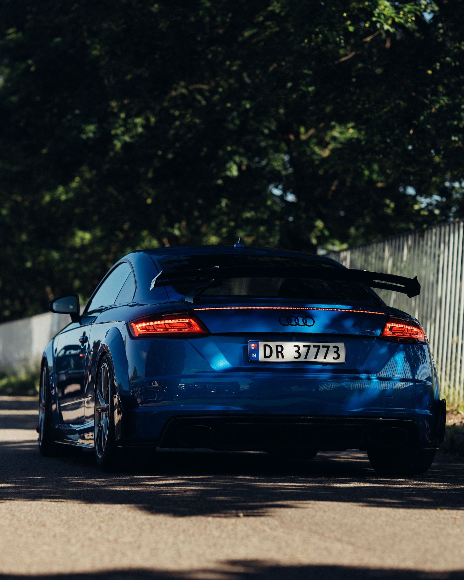 Blue performance cars with sleek designs photographed at sunset.