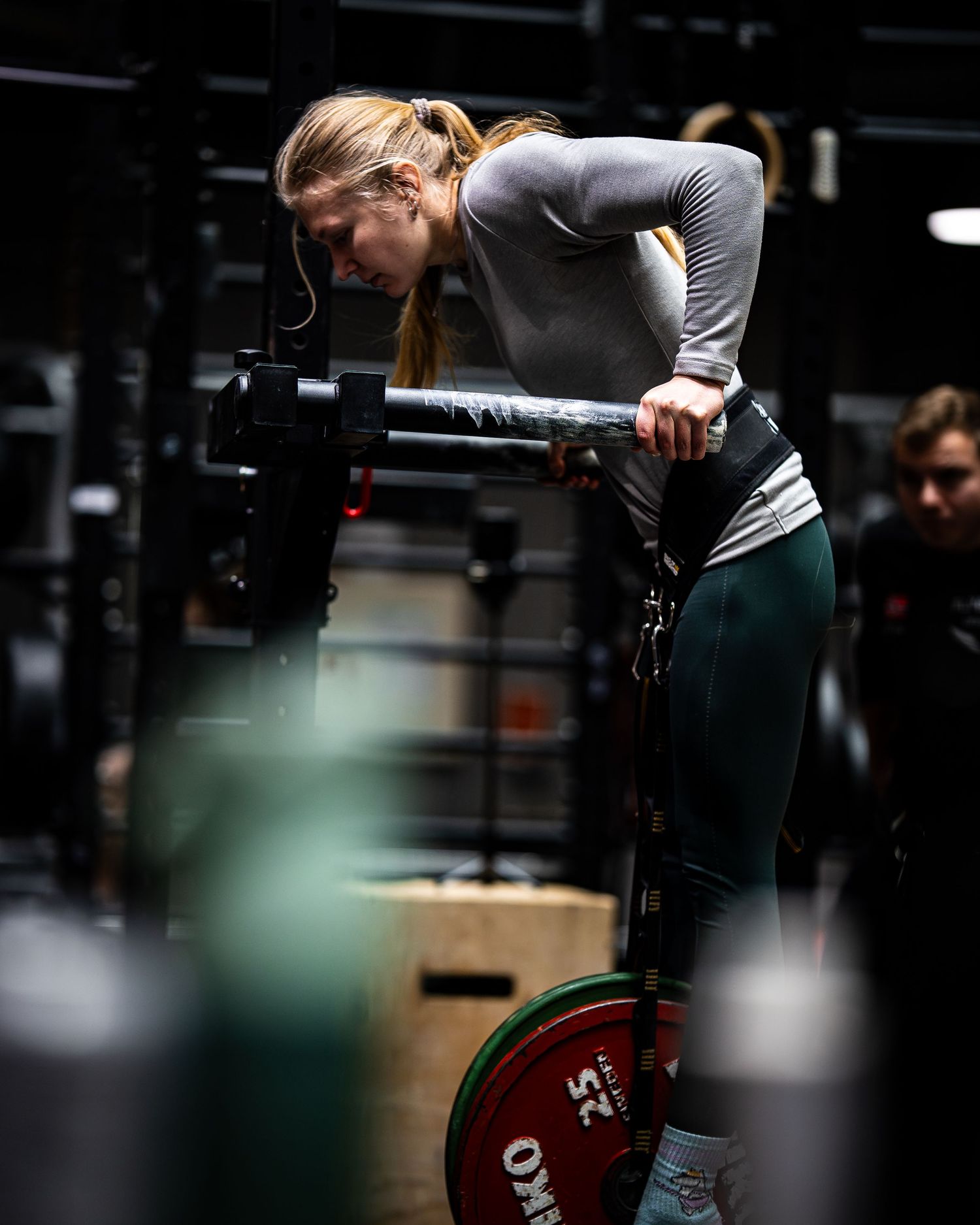 Athlete performing dips exercise with proper form in dark gym setting.