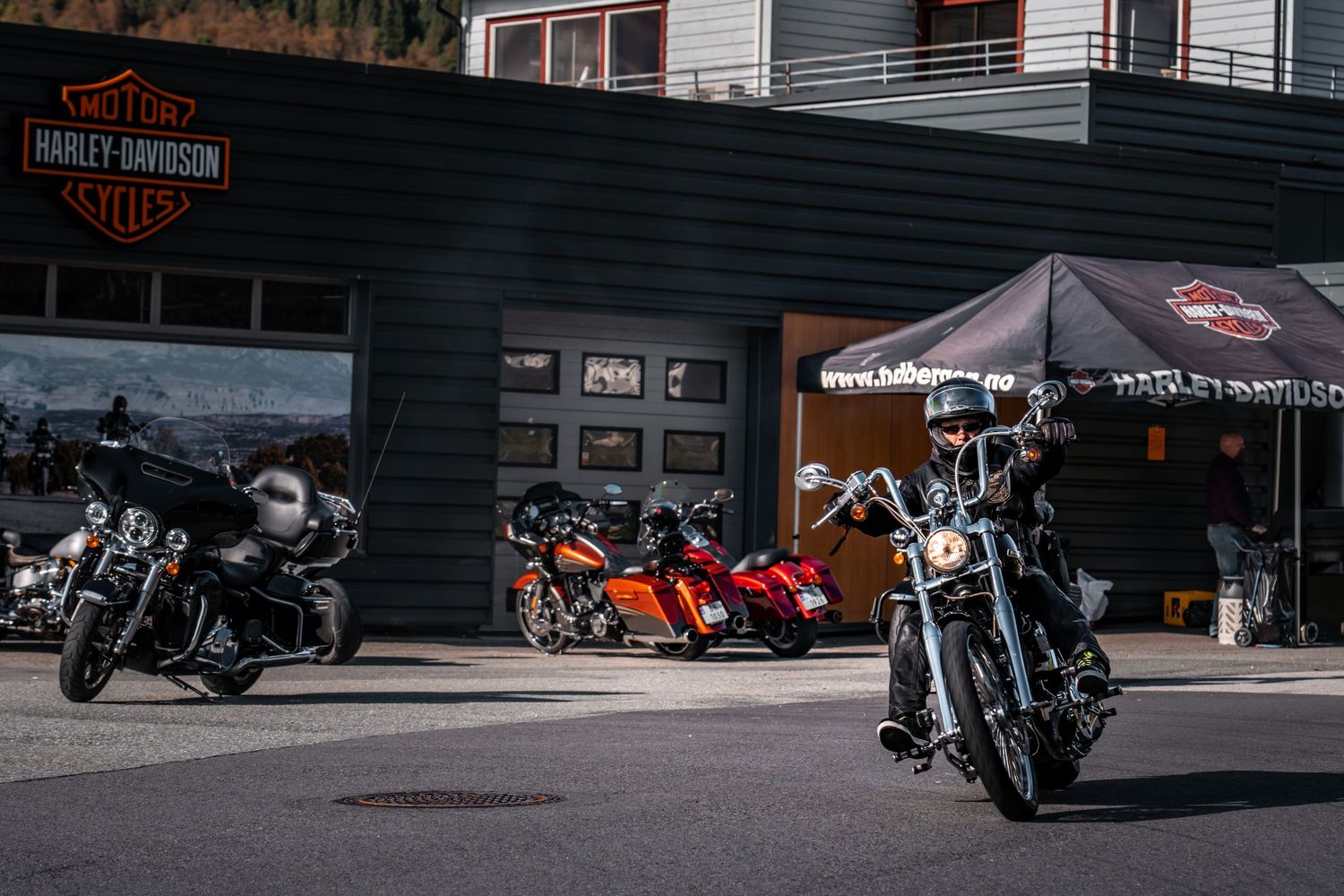 Wide view of Harley-Davidson dealership exterior with multiple bikes parked outside.