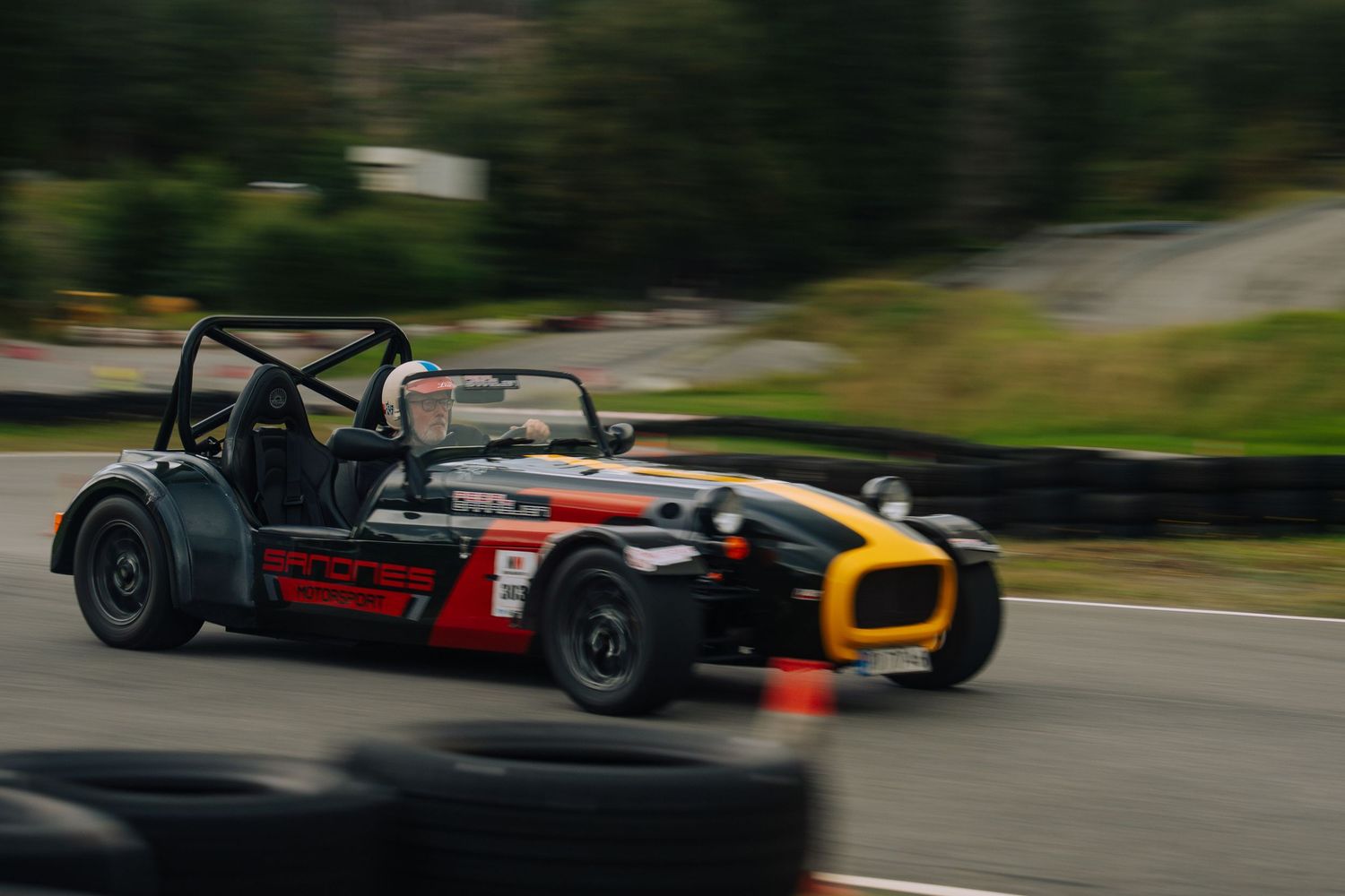 Race cars speed through a winding track during a competitive motorsport event.