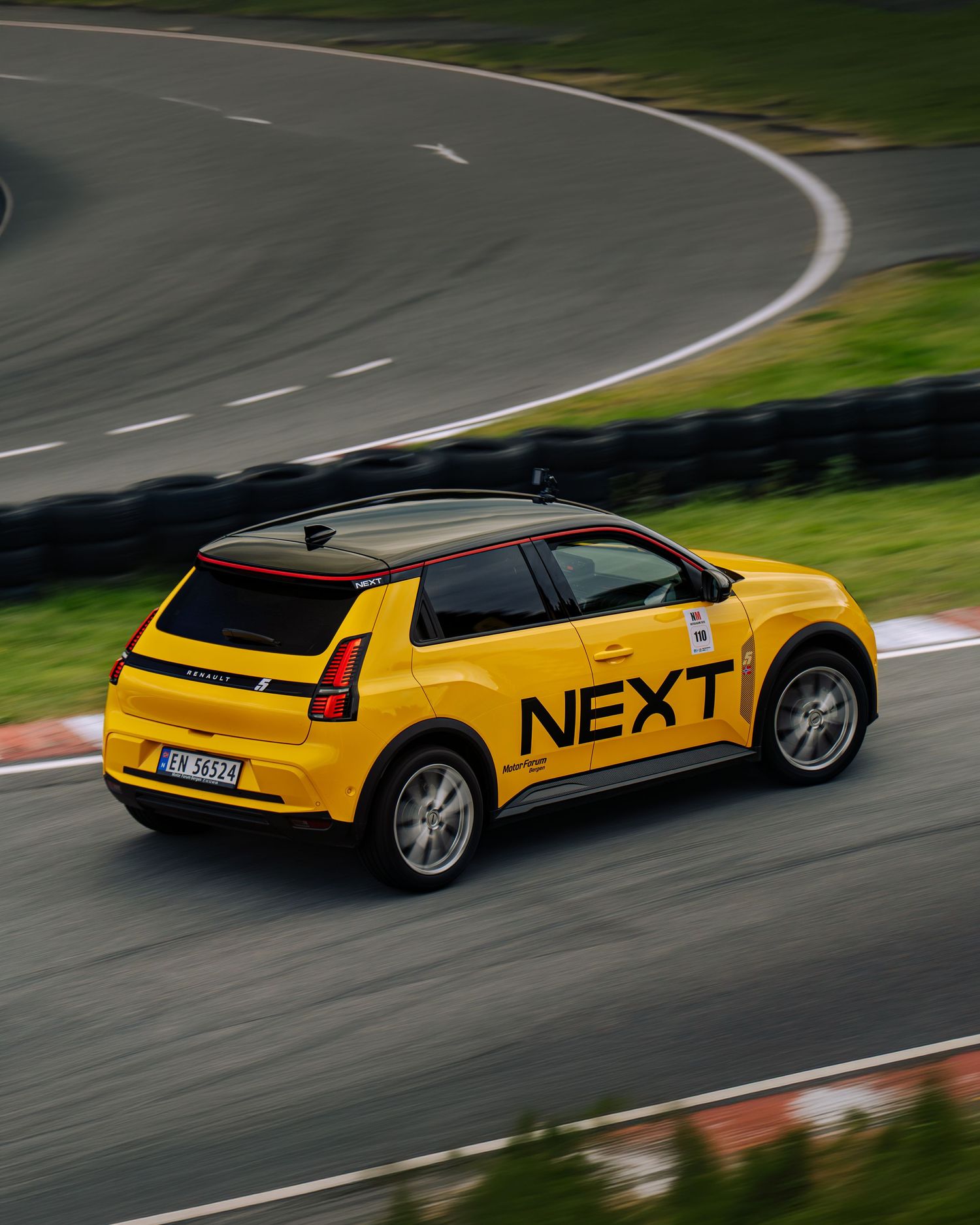 A bright yellow concept car with sleek angular design drives around a curved racetrack through multiple action shots.