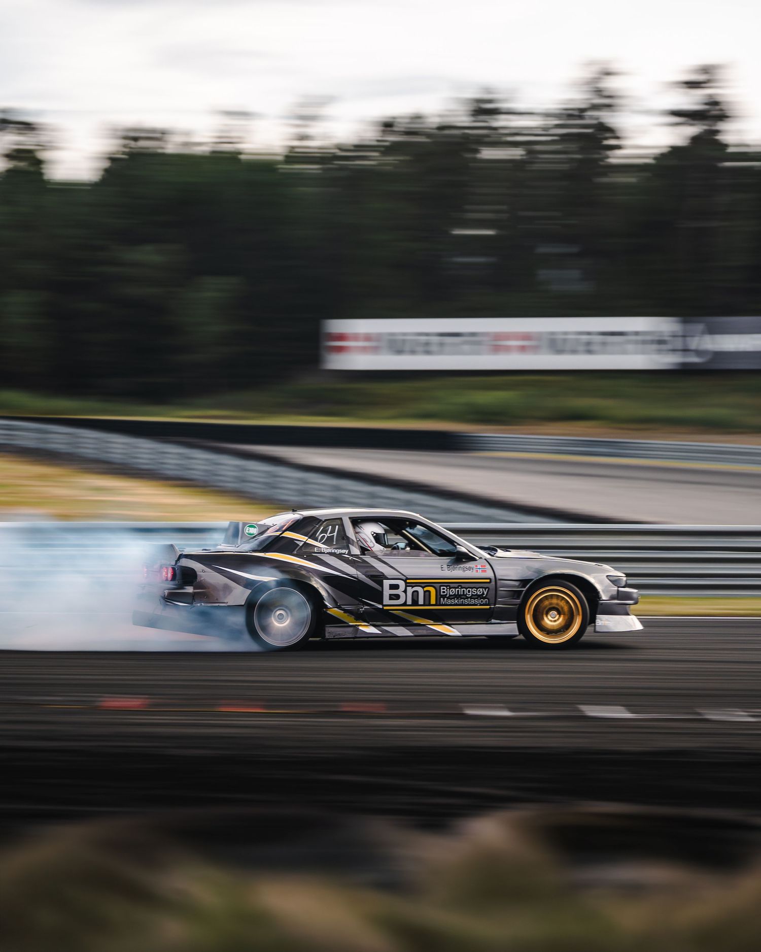 A race car speeds past on a track with motion blur creating a dramatic sense of velocity and movement.