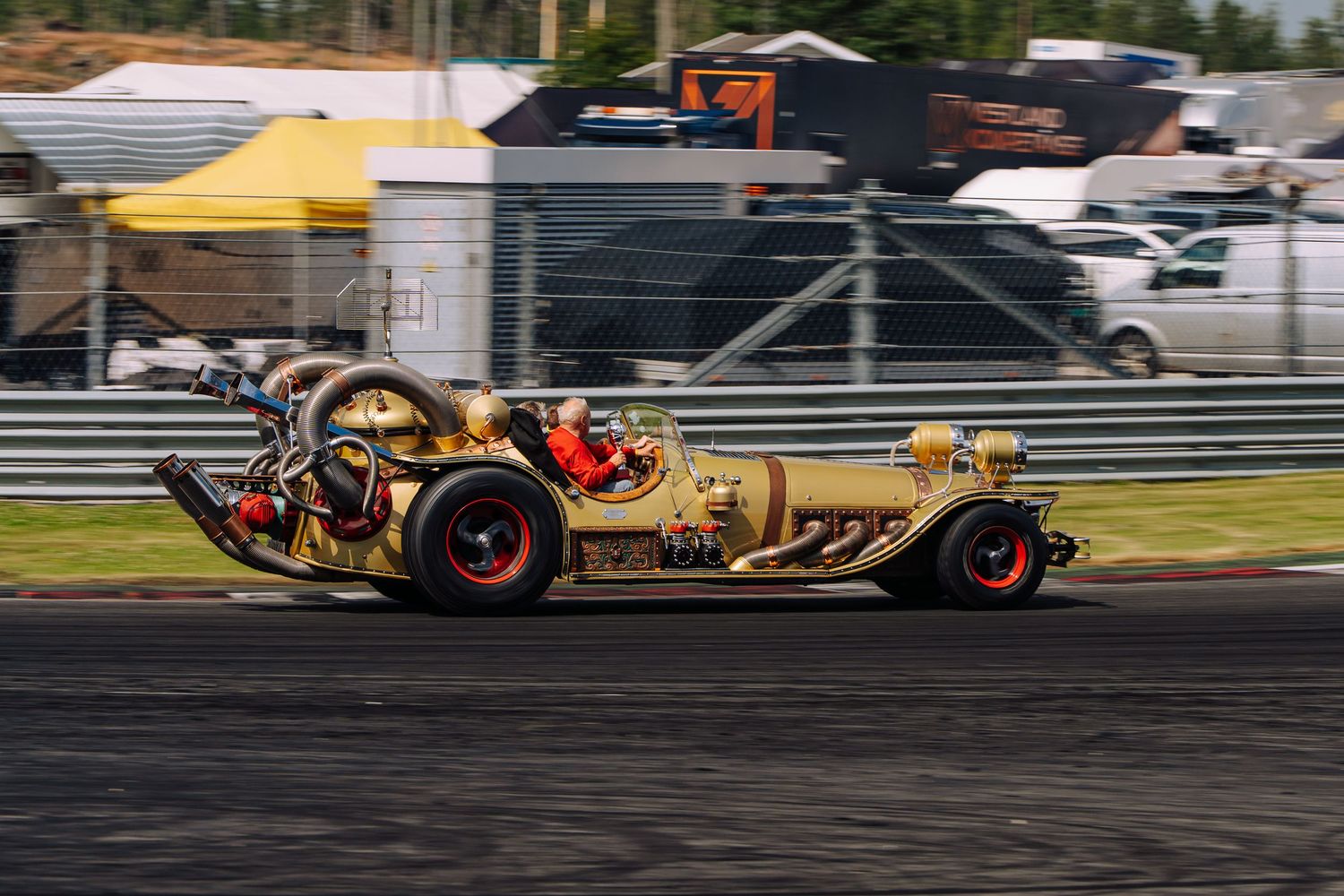 Racing cars drift around a track corner during a high-speed motorsport competition event.