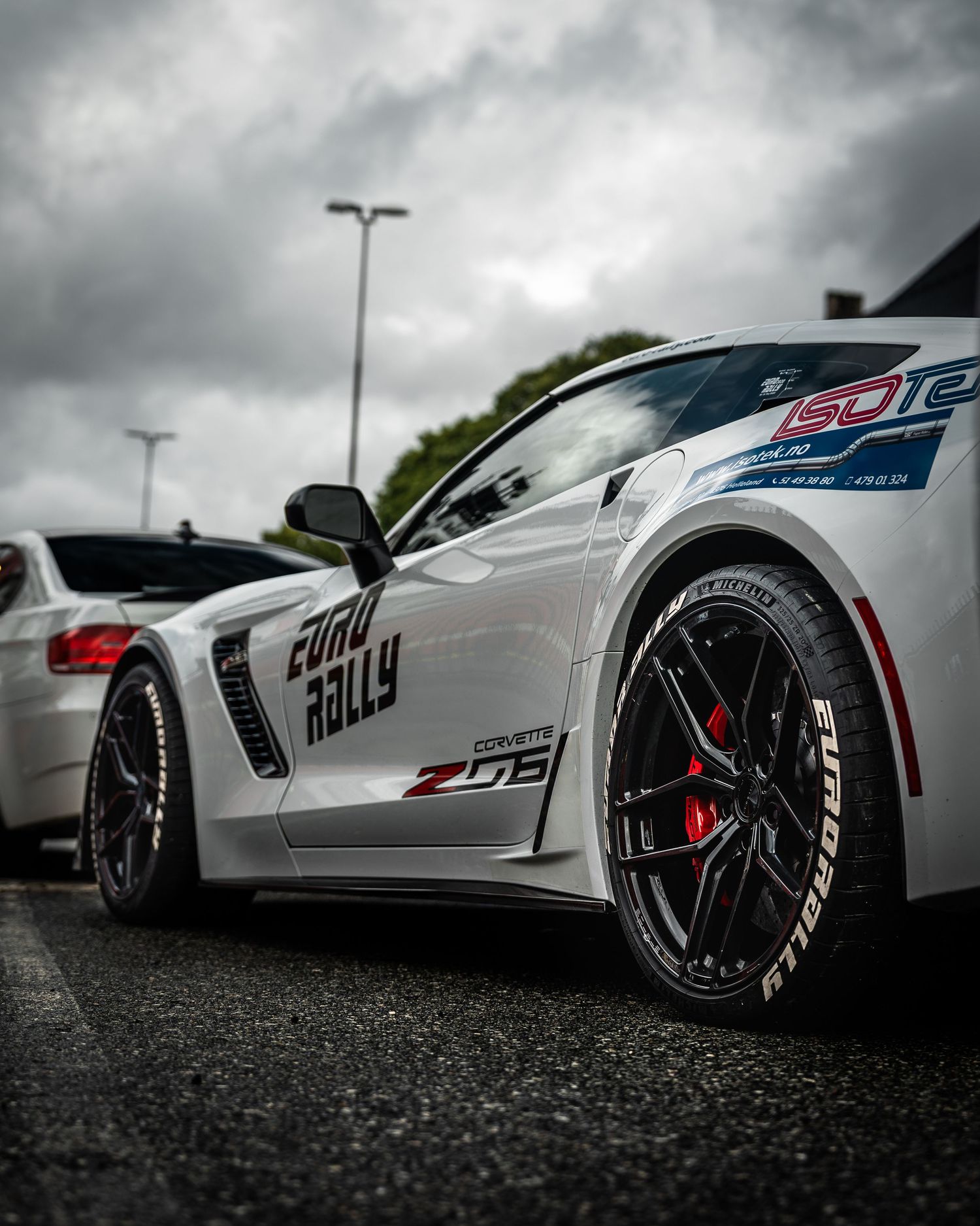 White Chevrolet Corvette Z06 race car with custom wheels photographed from low angle.