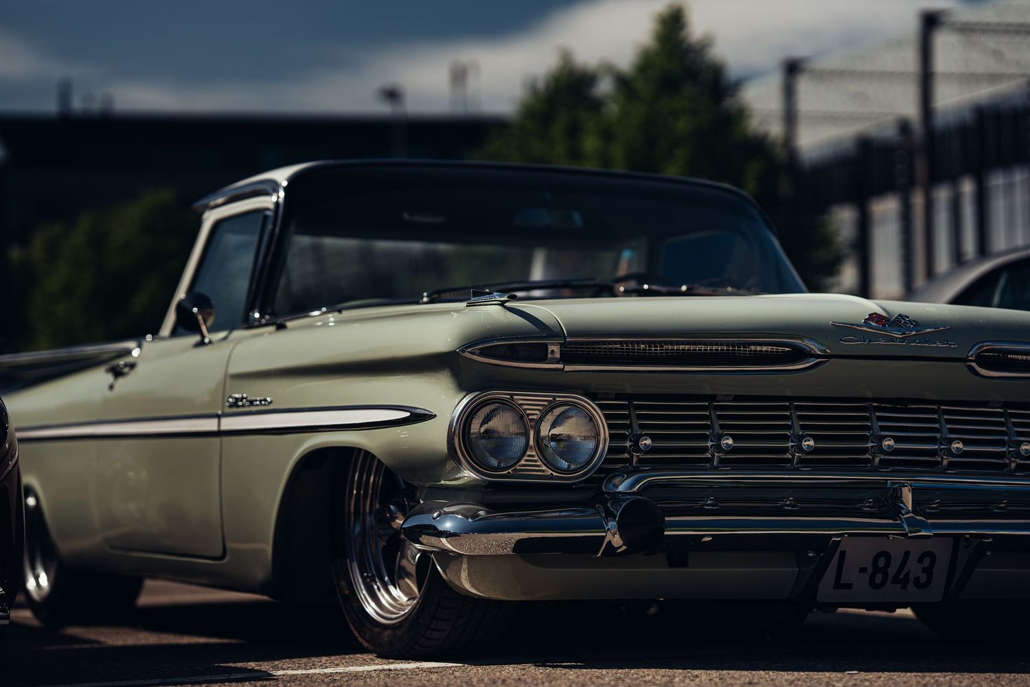 Classic Chevrolet Impala in beige showing sleek vintage styling at a car meet.