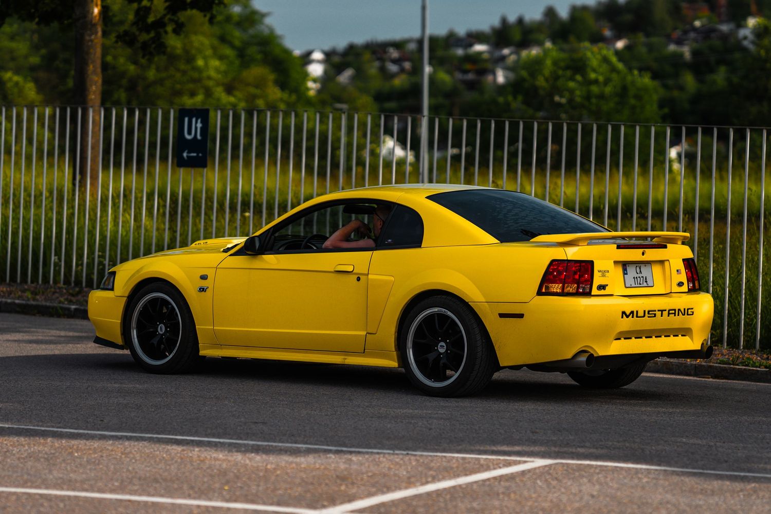 Yellow sports cars displayed in a row at an outdoor car show.