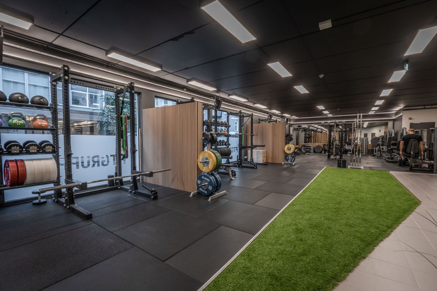 Spacious gym layout featuring weight equipment and artificial turf flooring section.